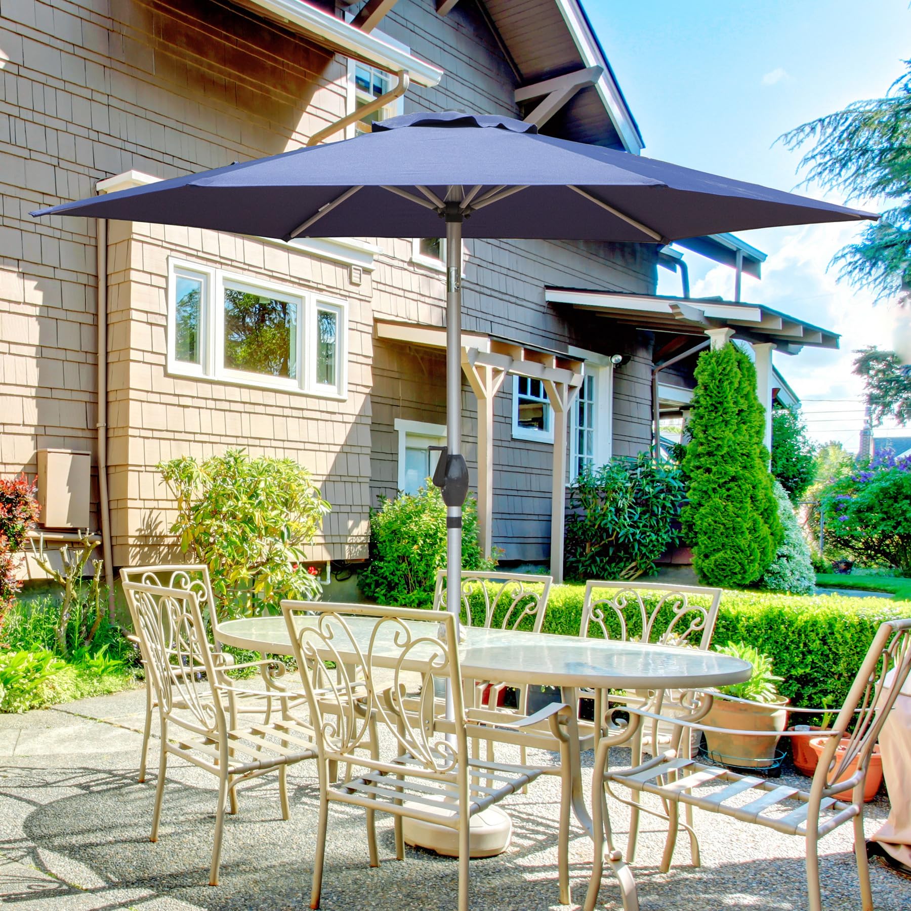 Dark navy patio umbrella providing shade for a cast aluminum patio dining set