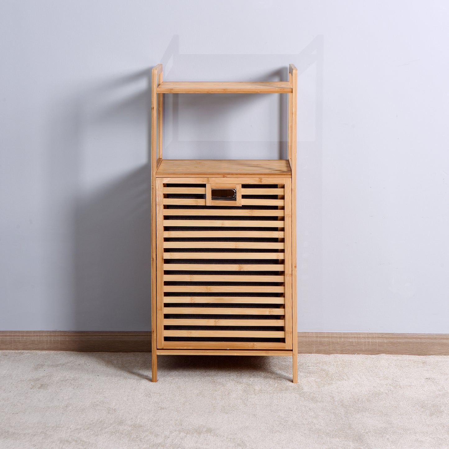 Natural bamboo laundry hamper with slatted door and two shelves for bathroom storage