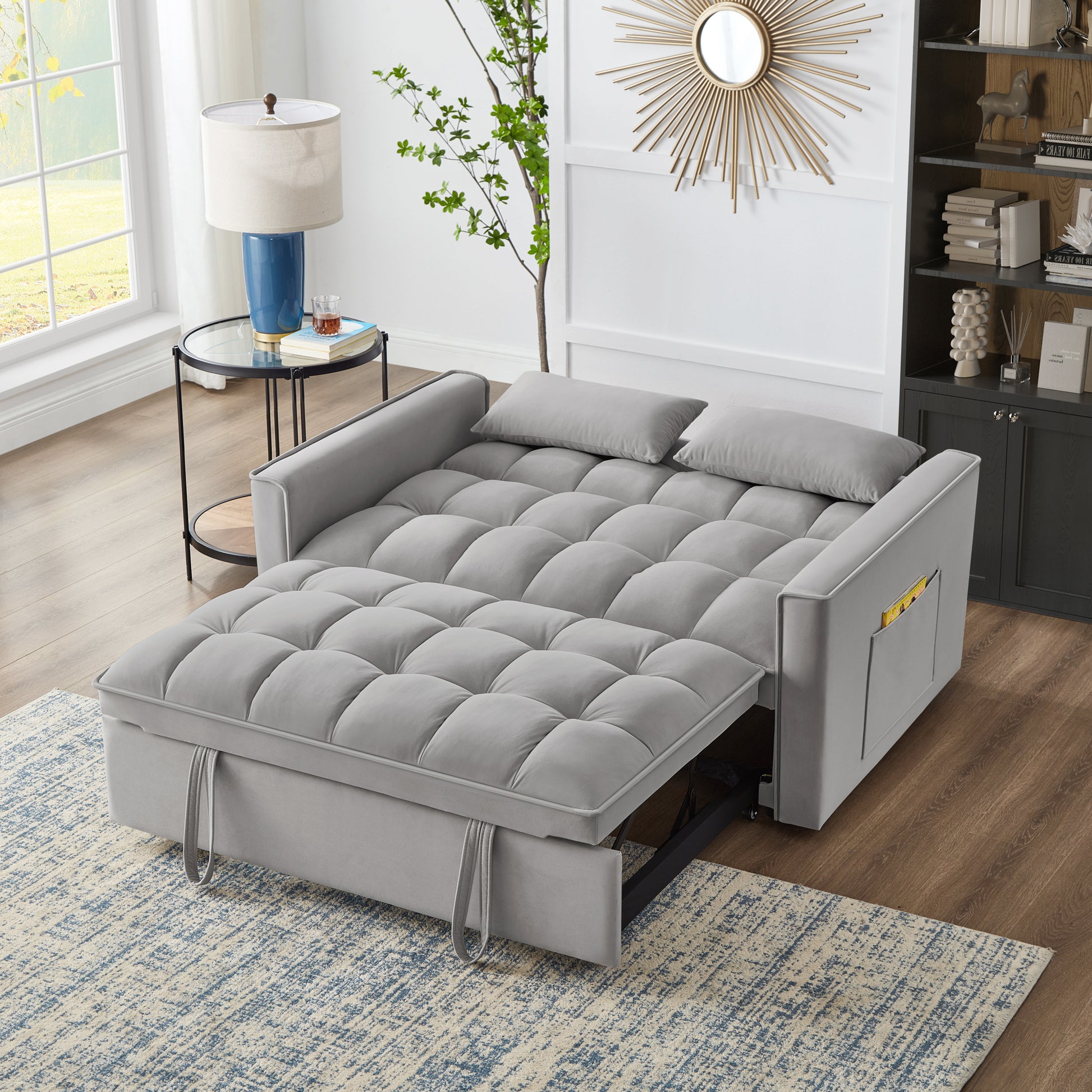 Grey tufted sofa bed with plush cushions extending for sleeping