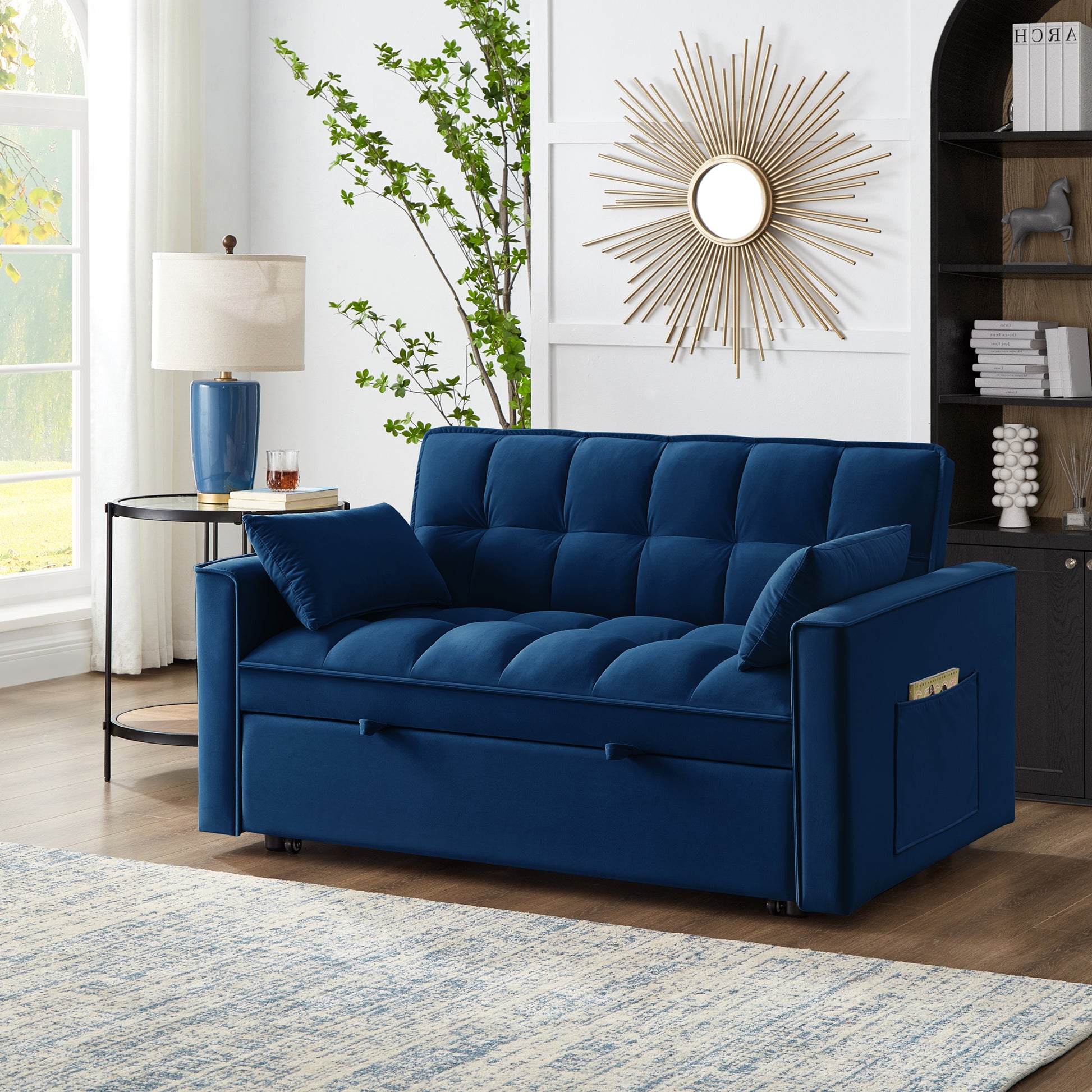 Plush navy blue velvet sofa bed with tufted cushions and convenient side pocket