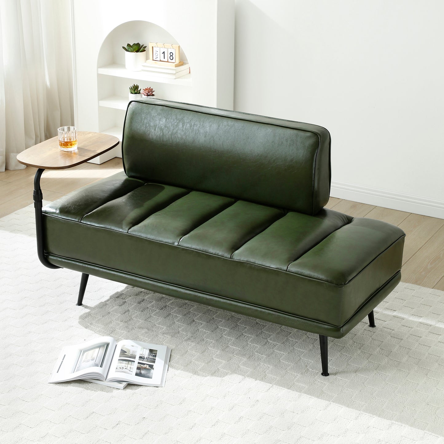 Deep green faux leather loveseat with channel tufting and slim black legs