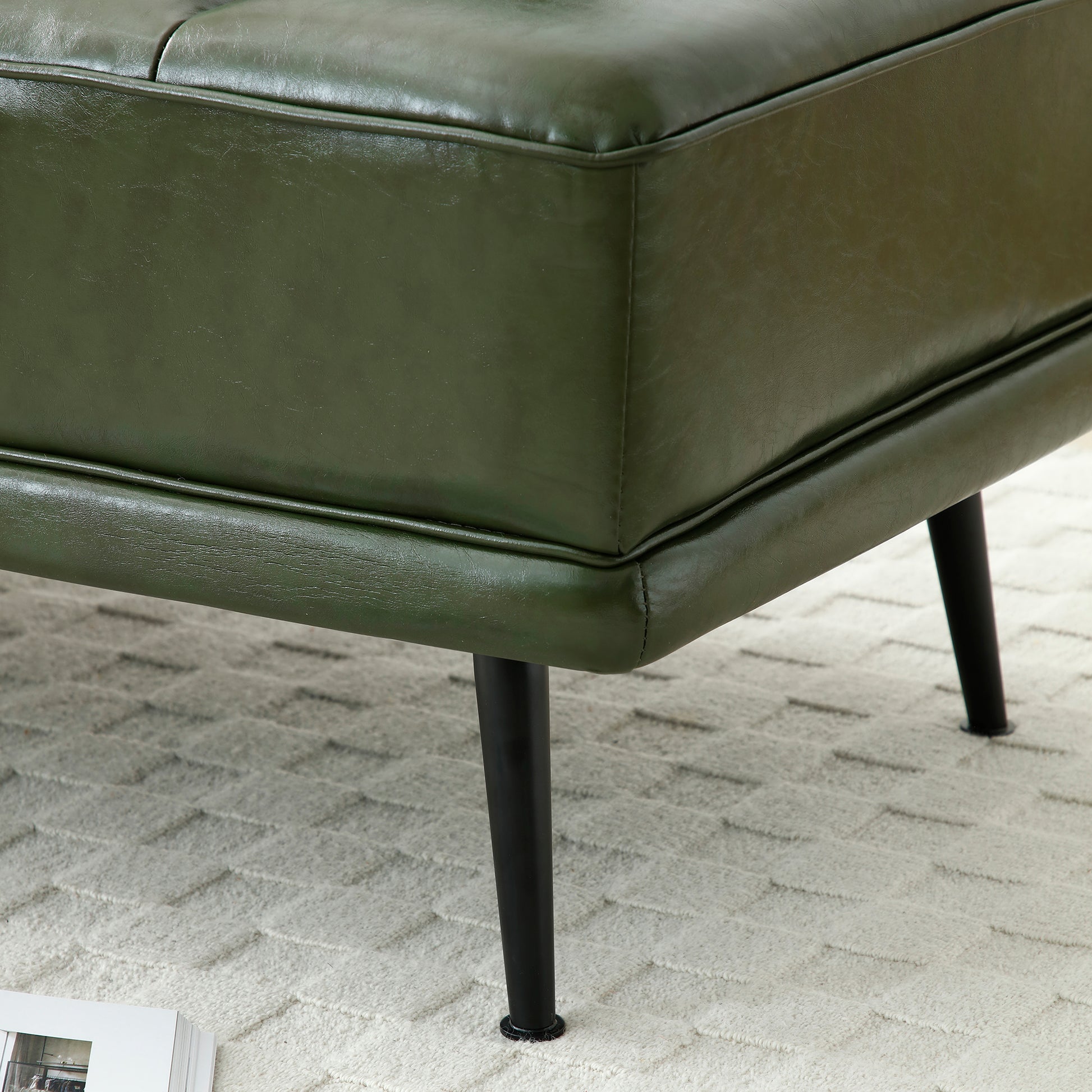 Deep green faux leather ottoman with tufted seat and black metal legs