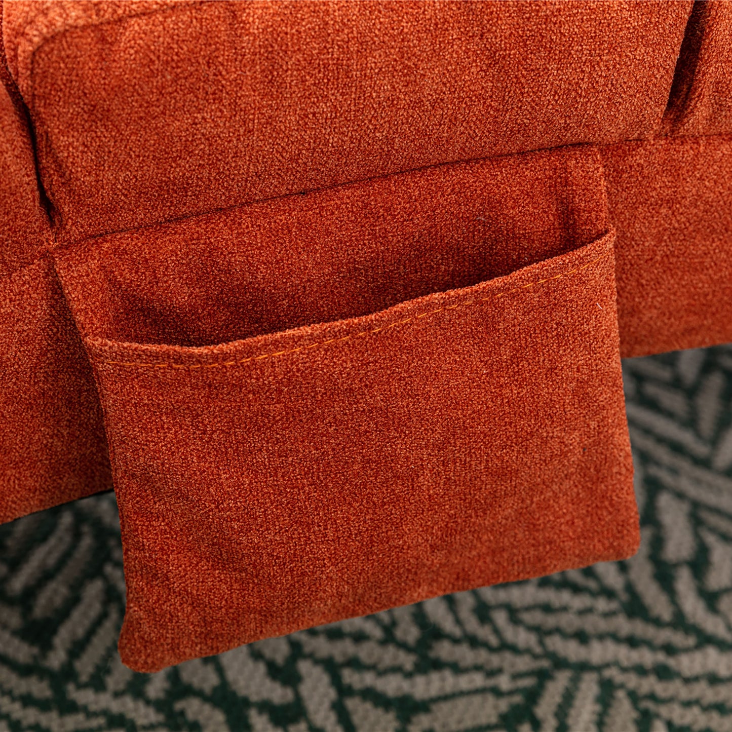 Closeup of an orange textured fabric sofa arm with a convenient side pocket for storage