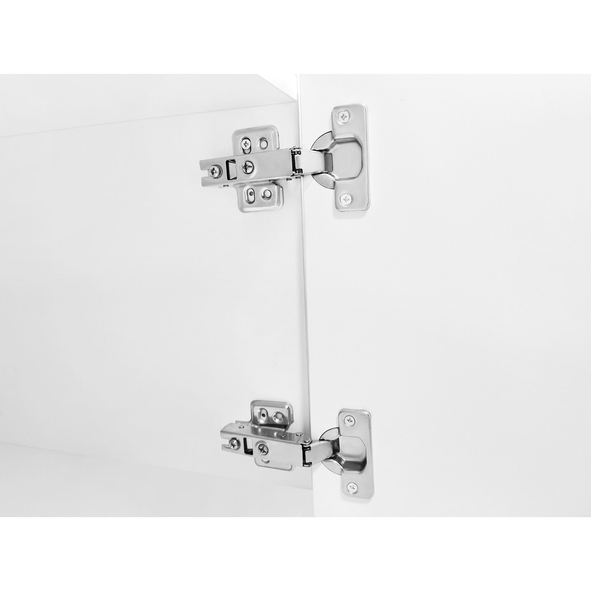 Closeup of two silver cabinet hinges on a white door showing detail and mechanism