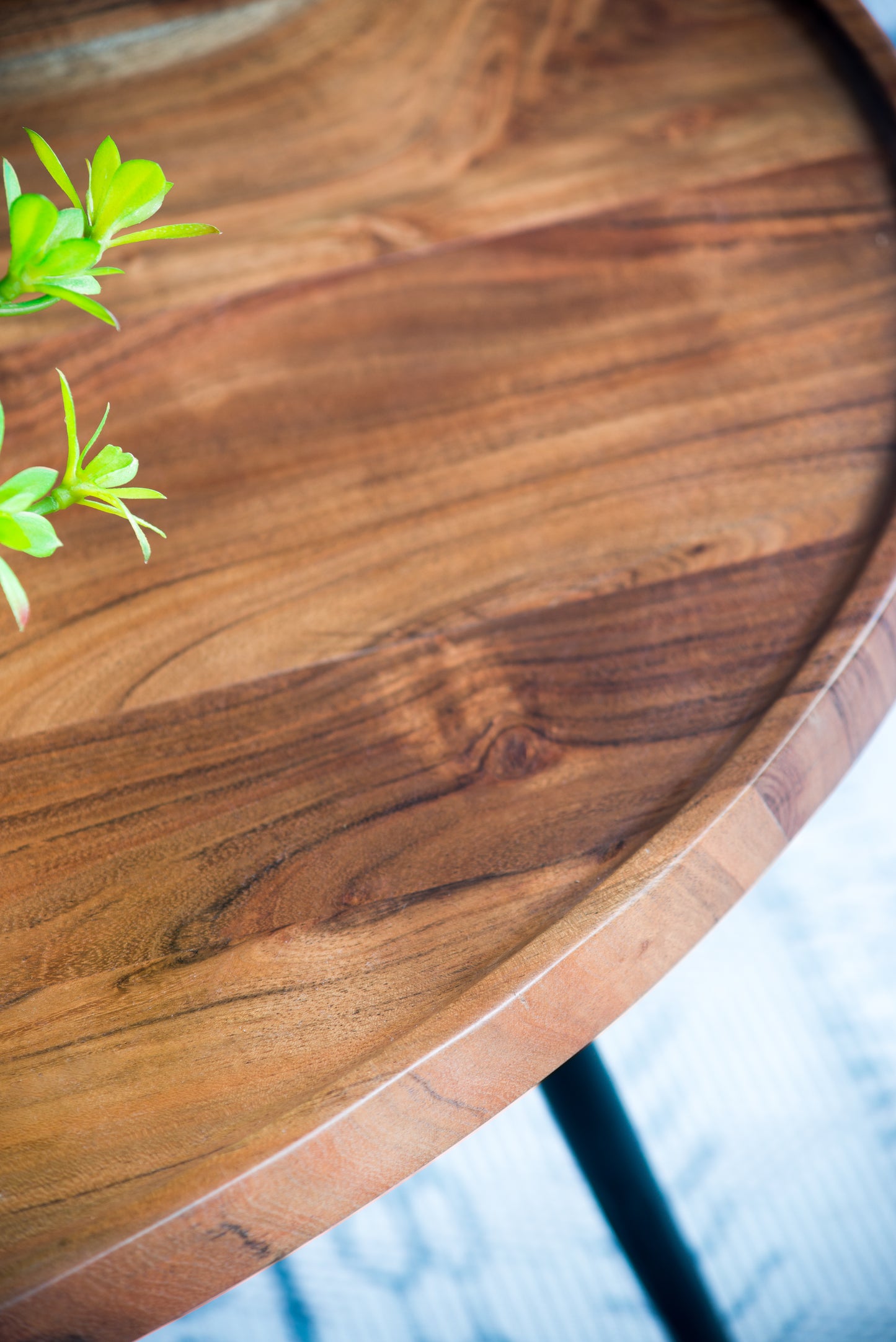Solid oak wood serving tray with natural grain texture and small green leaves accent