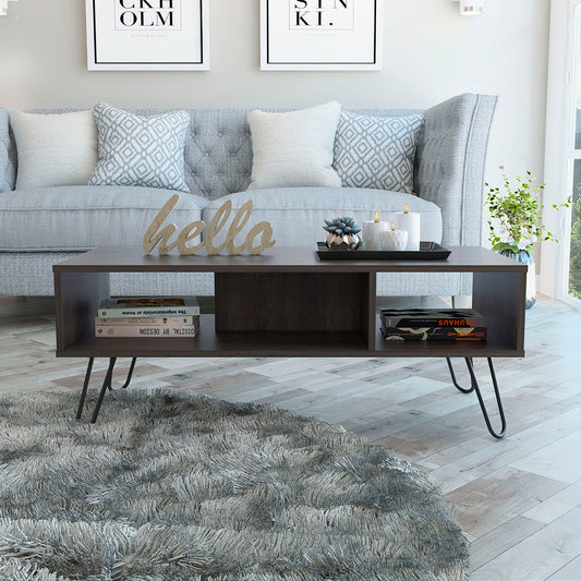 Dark brown particleboard coffee table with hairpin legs holding books and decor