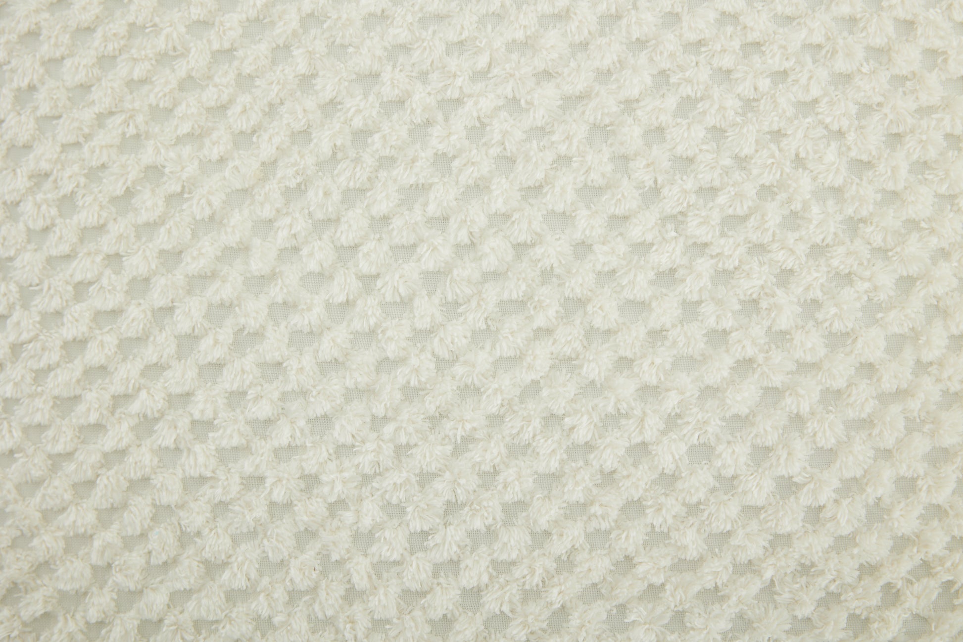 Cream textured fabric with a repeating diamond plush pattern