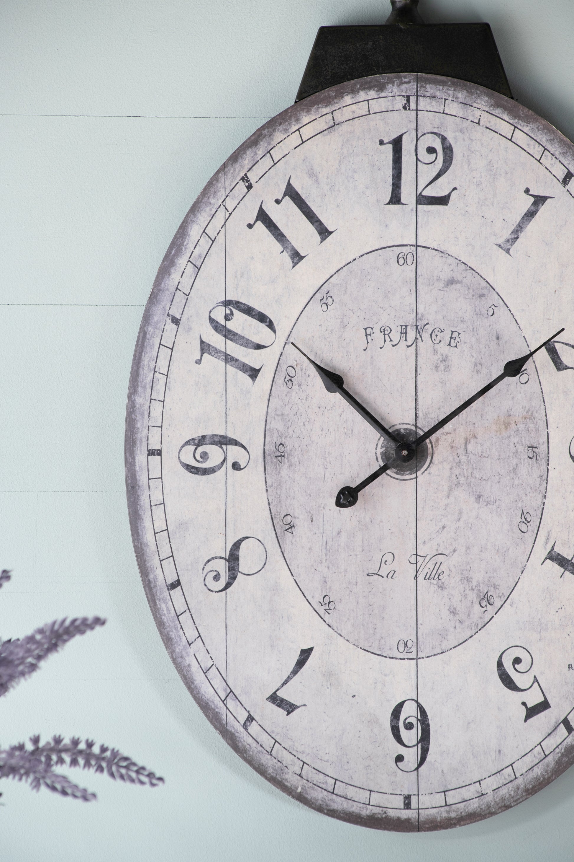 Distressed farmhouse wall clock with vintage Roman numerals and dark metal frame