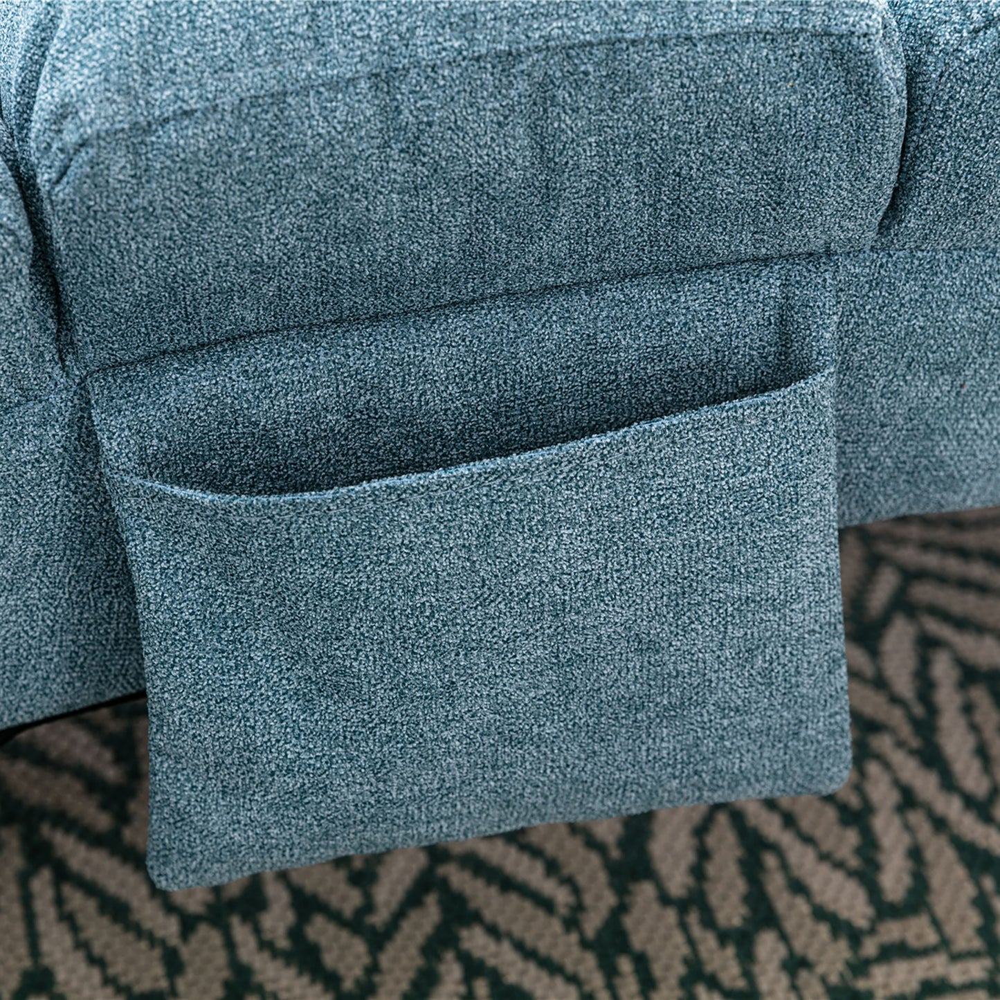 Teal fabric armchair with builtin side pocket for magazines and remotes