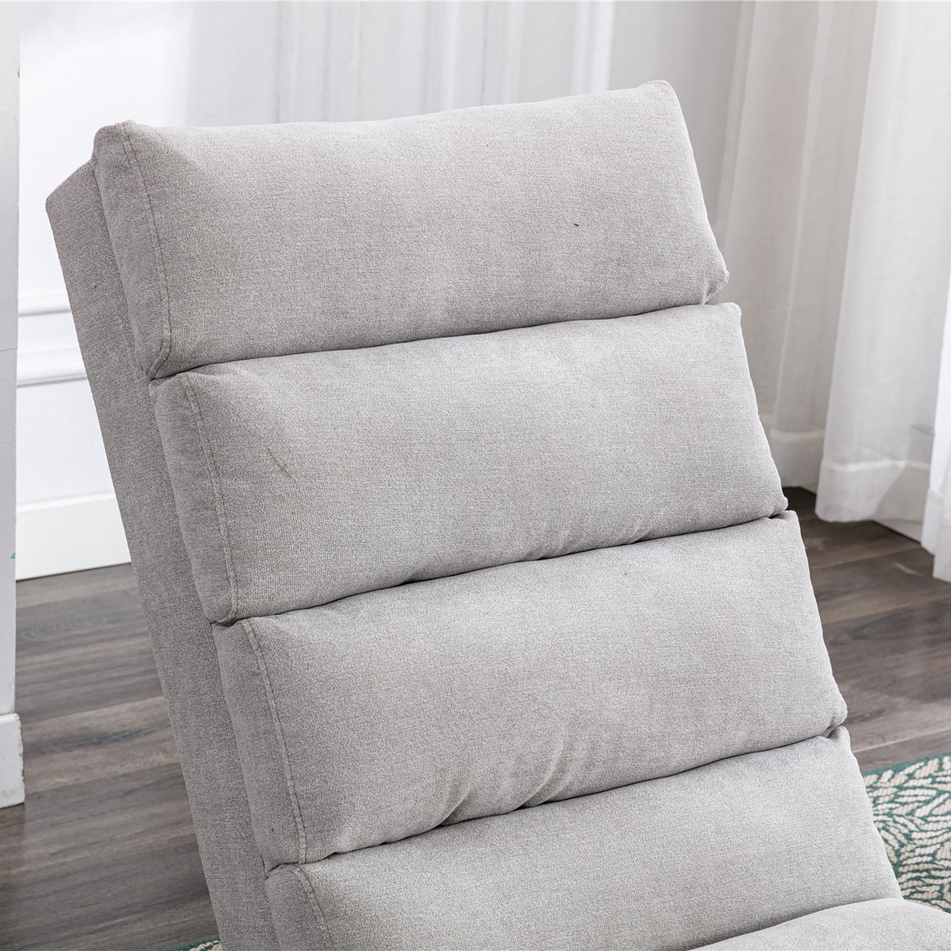 Closeup of a light gray fabric recliner showing its plush cushioning