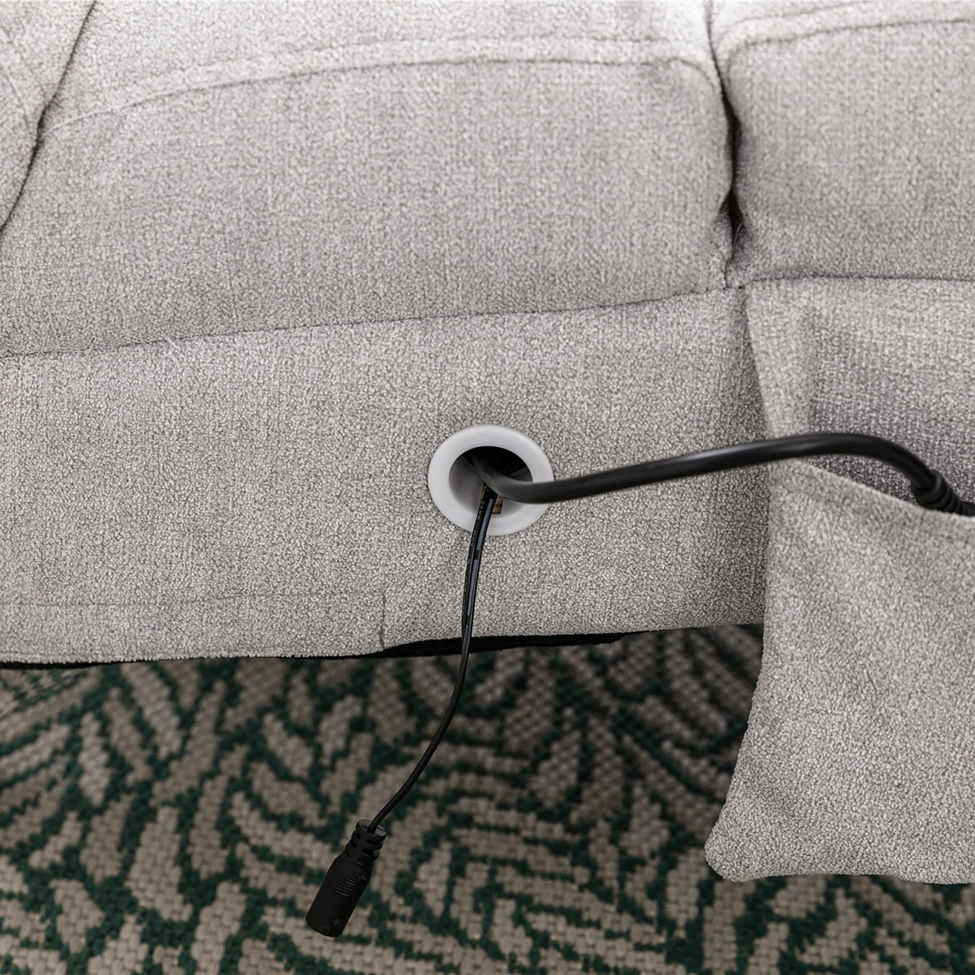 Gray recliner sofa base with integrated power cord grommet detail