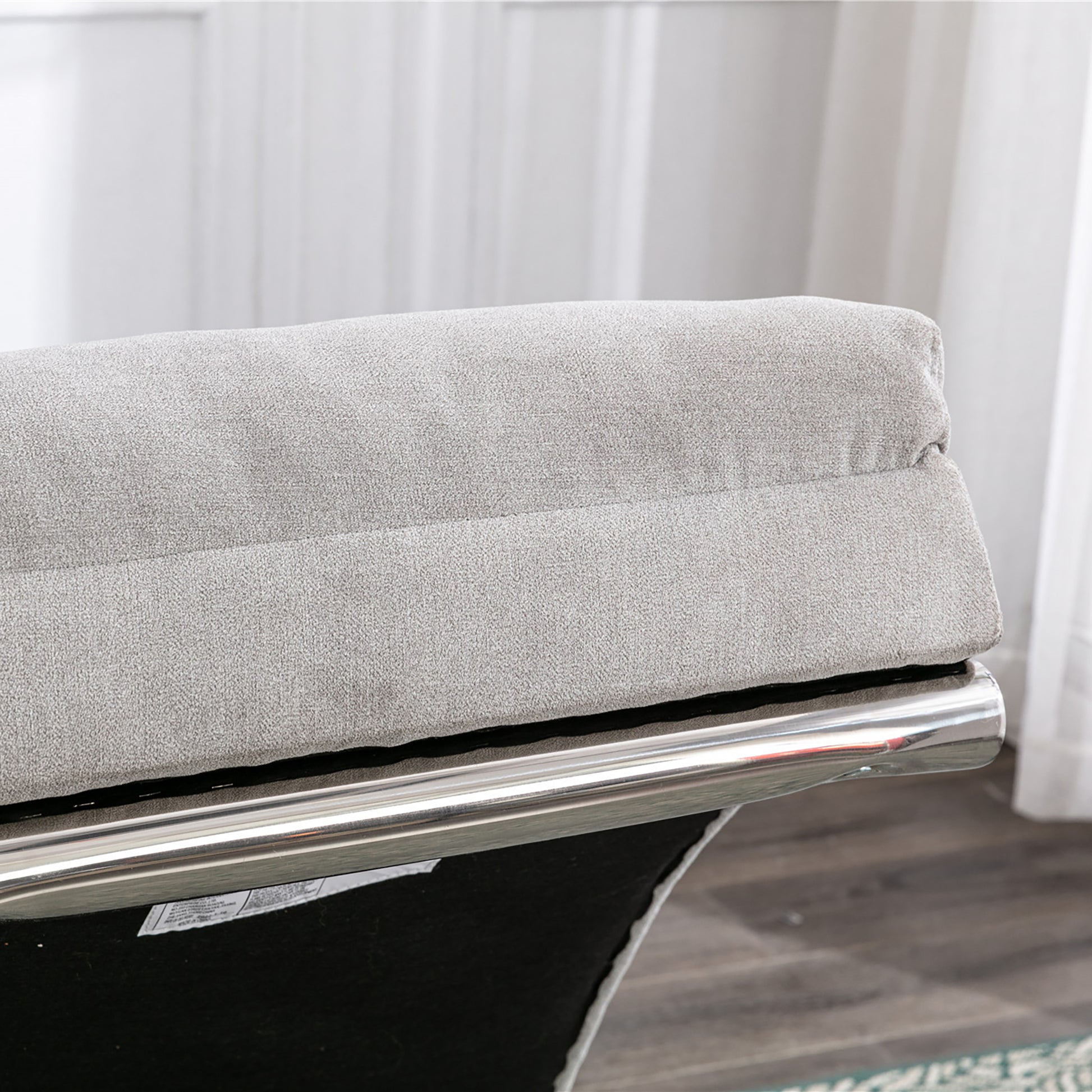 Light gray fabric sofa cushion with polished chrome accent trim