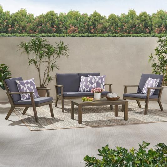 Grey upholstered patio sofa with patterned accent pillows on a rug
