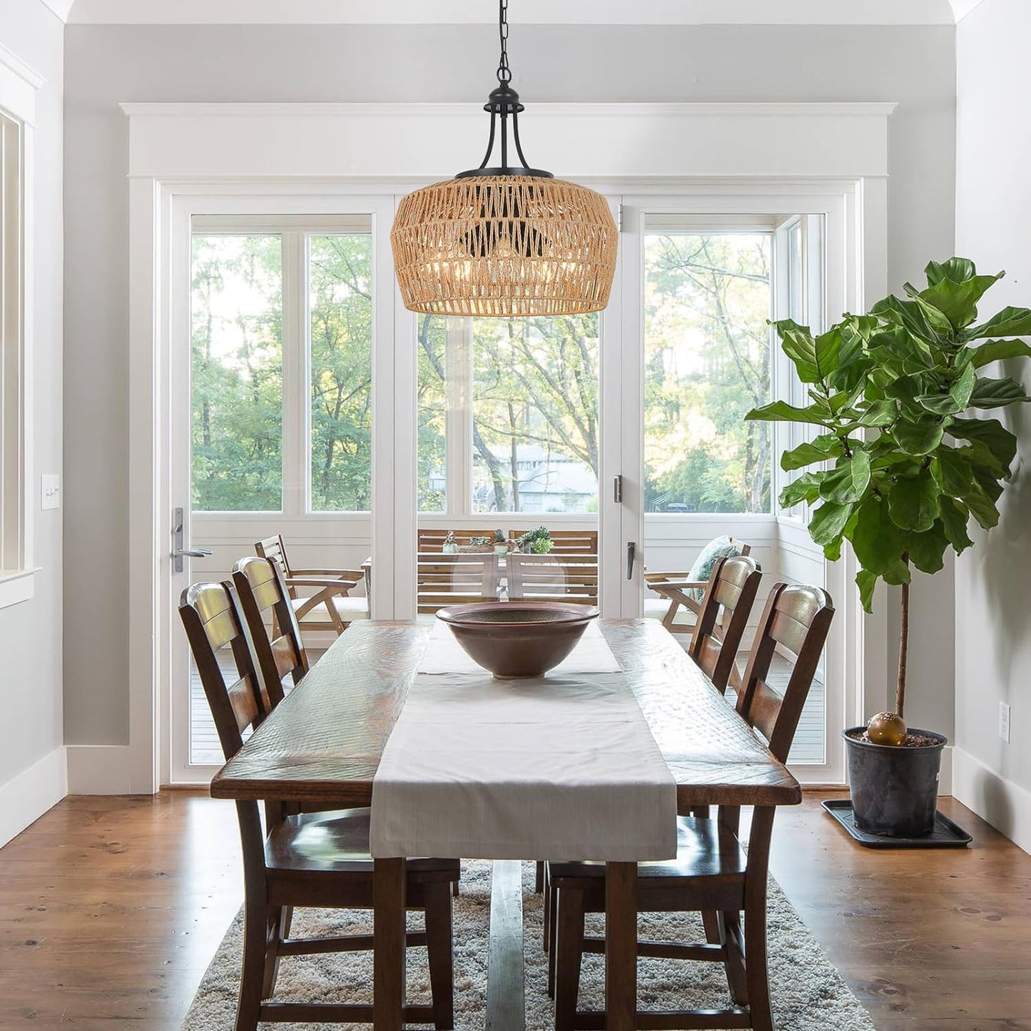 Rustic wicker pendant light with a natural woven texture hangs above a wooden dining table setting
