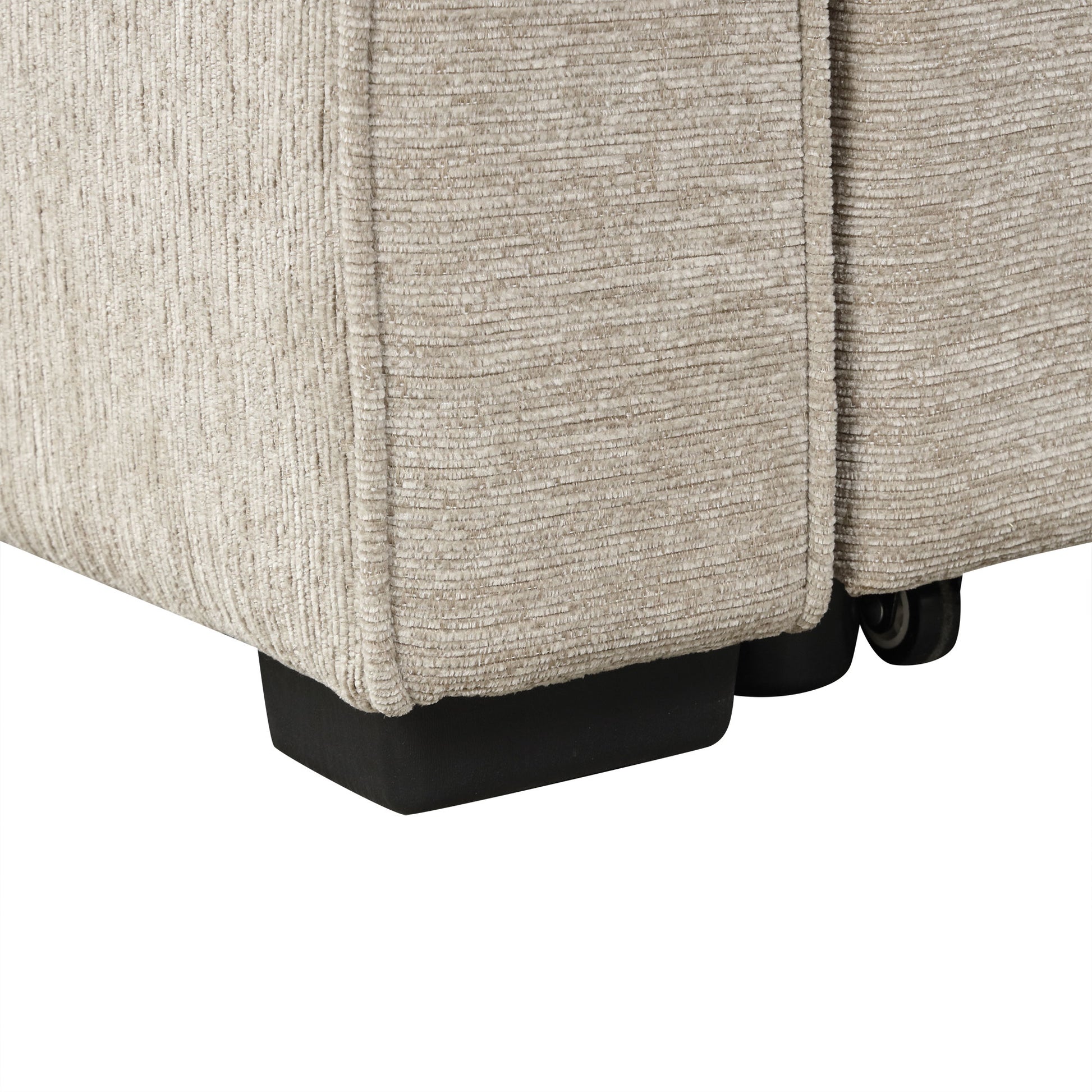 Closeup of beige corduroy fabric on a sofa armrest with black feet visible