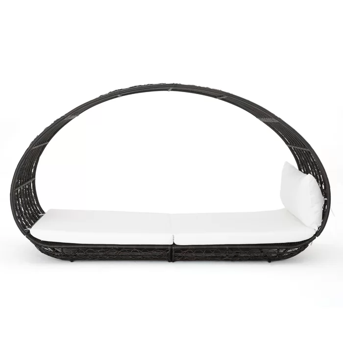 Modern black rattan daybed with canopy and white cushions for outdoor relaxation
