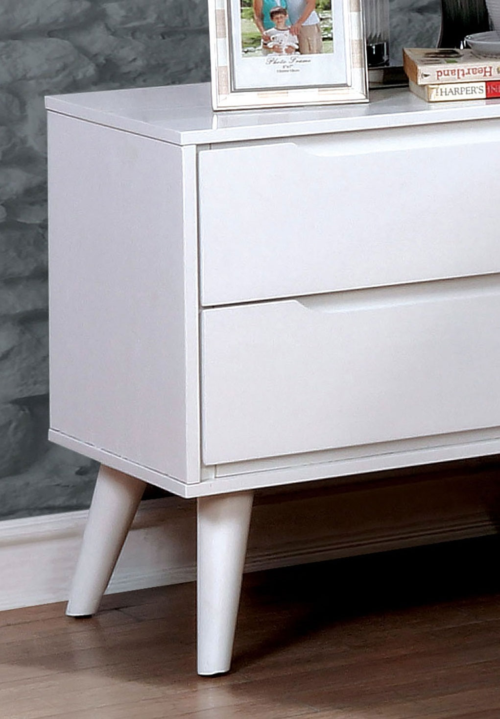 White twodrawer nightstand with tapered legs and sleek cutout handles