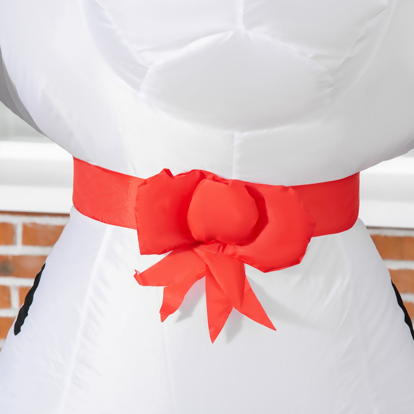 White inflatable snowman with a large red bow tied around its middle perfect for festive outdoor decor