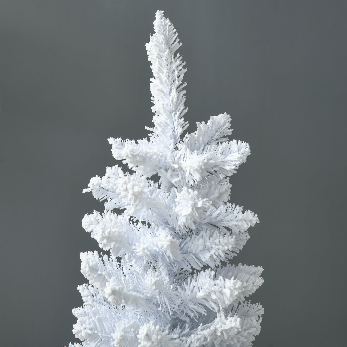 Closeup of a flocked white artificial Christmas tree with dense branches ideal for winter decor