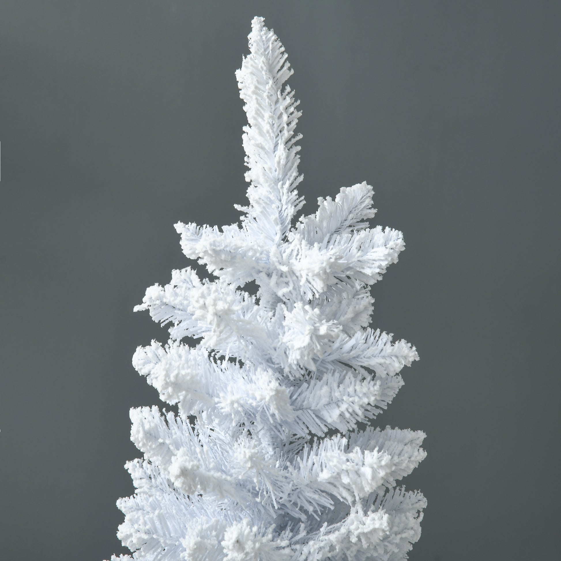 Closeup of a flocked white artificial Christmas tree with dense branches ideal for winter decor