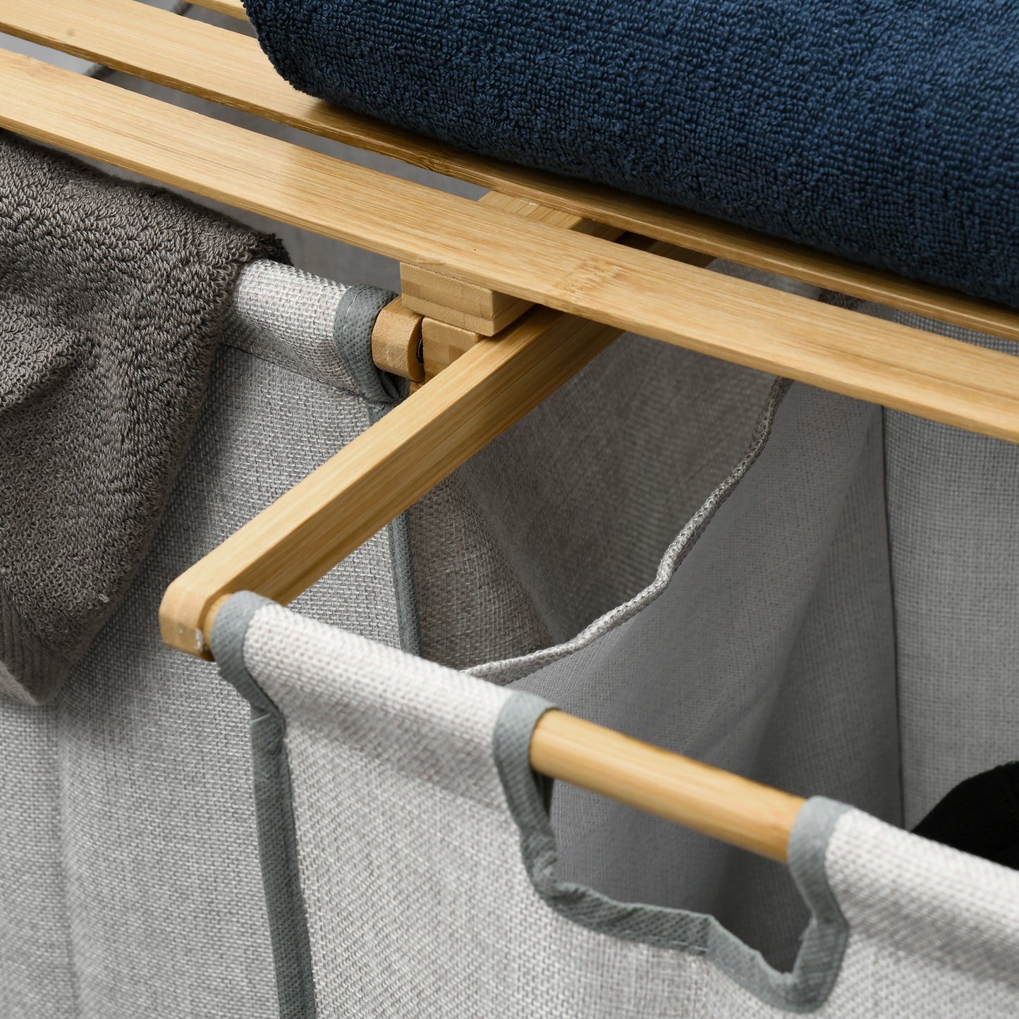 Bamboo frame laundry basket with grey fabric bins and rolled towels