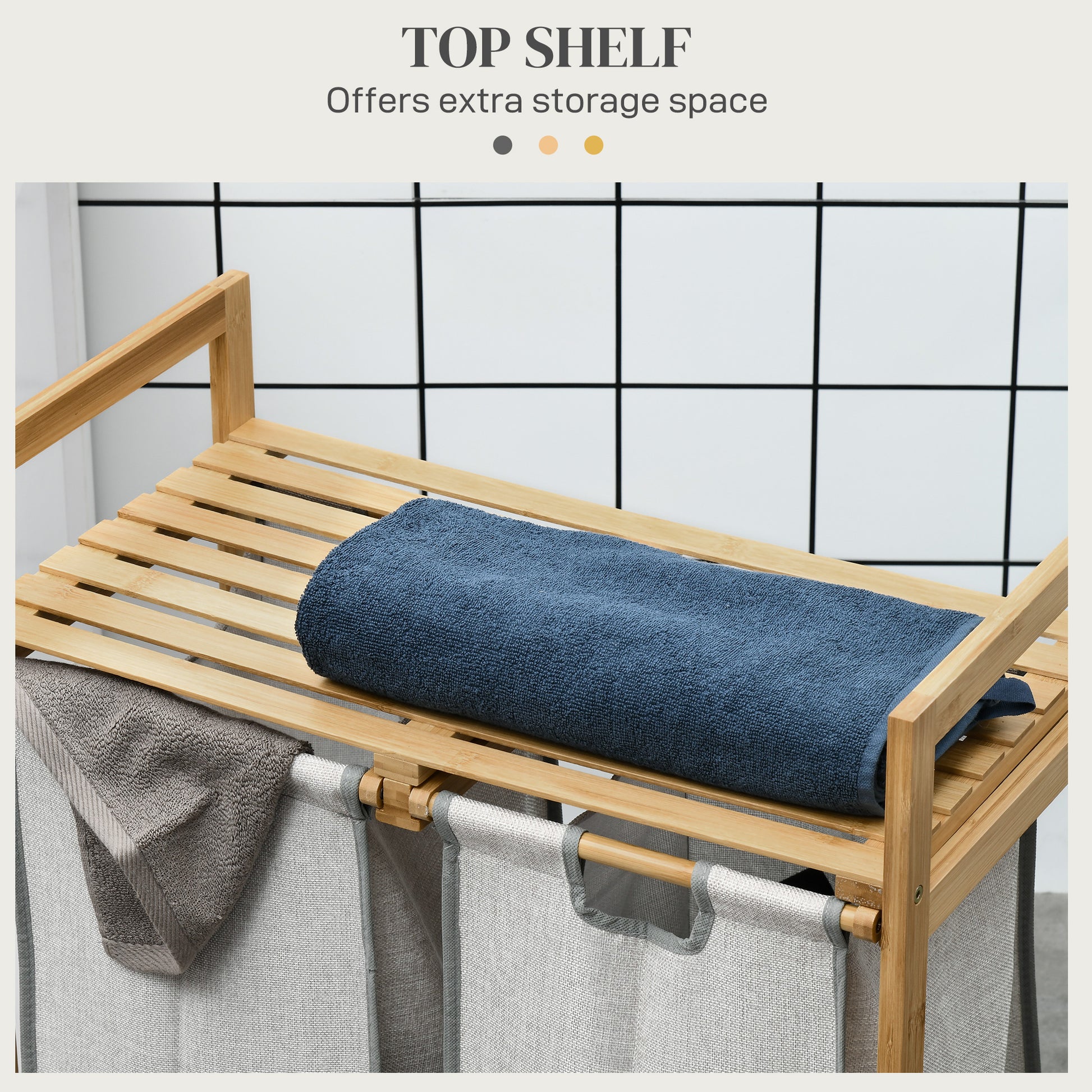Bamboo laundry sorter with three grey fabric bins and a top shelf holding a navy blue towel