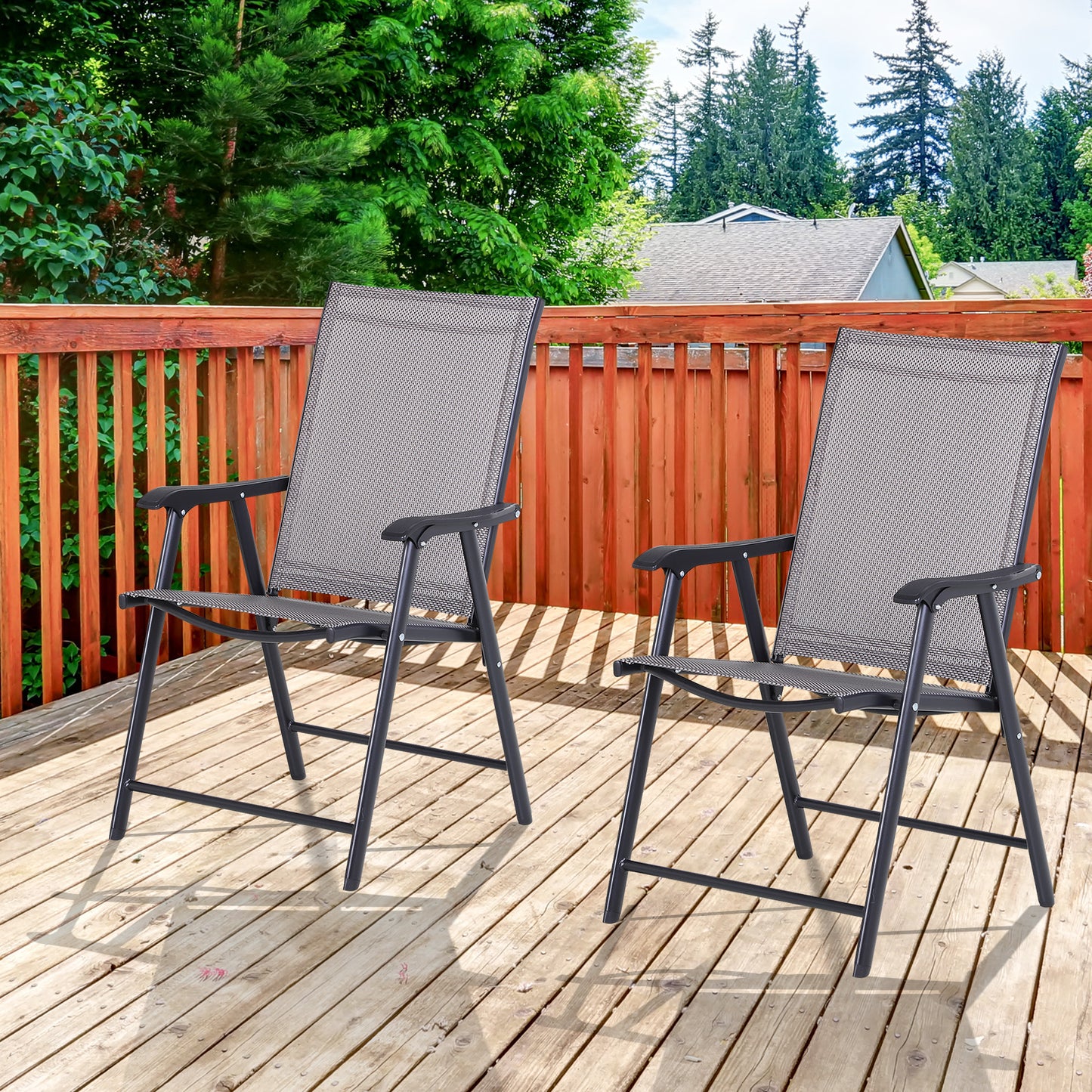 Two black metal folding chairs with grey mesh seats and backs on a wooden deck