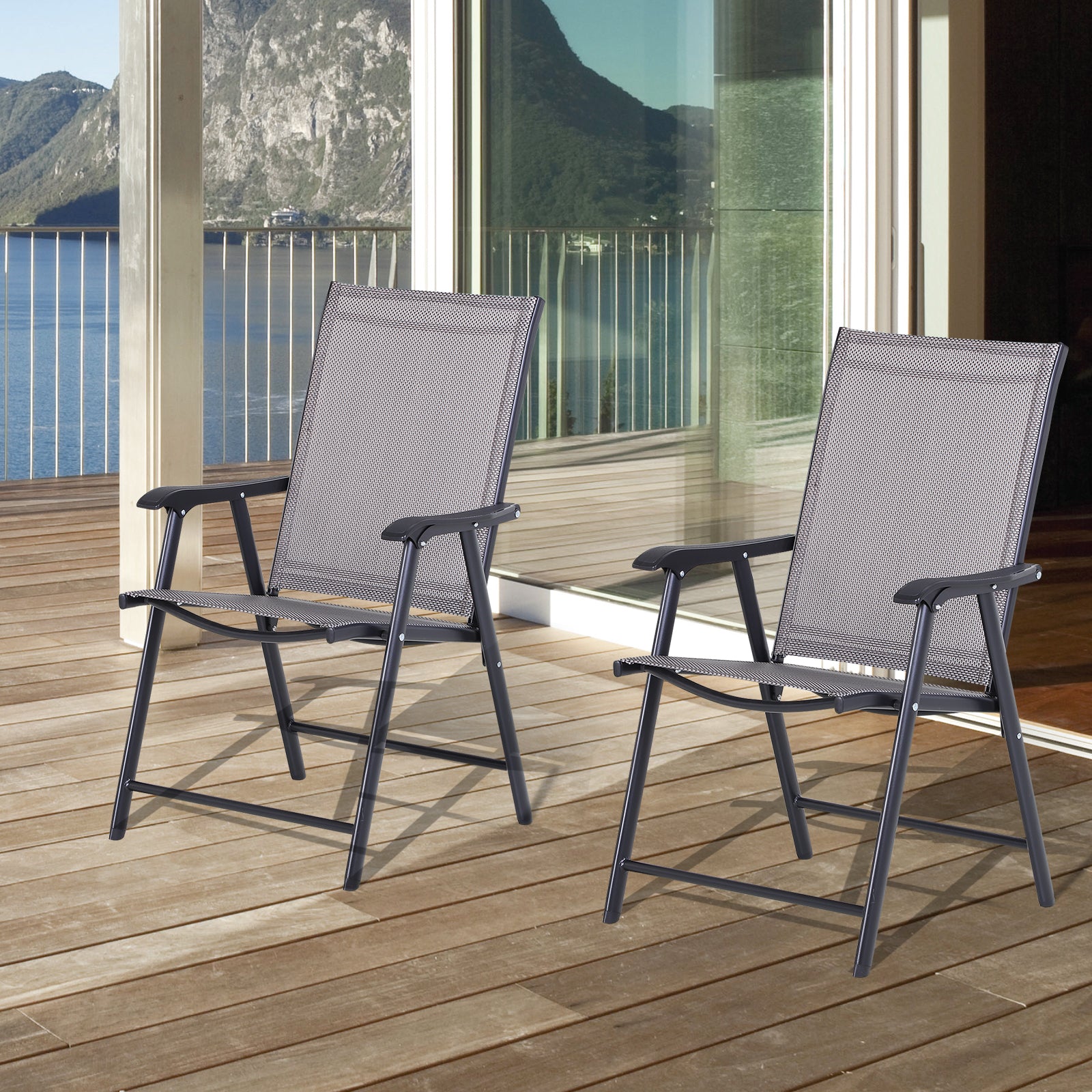 Two black mesh folding chairs with metal frames on a wooden deck