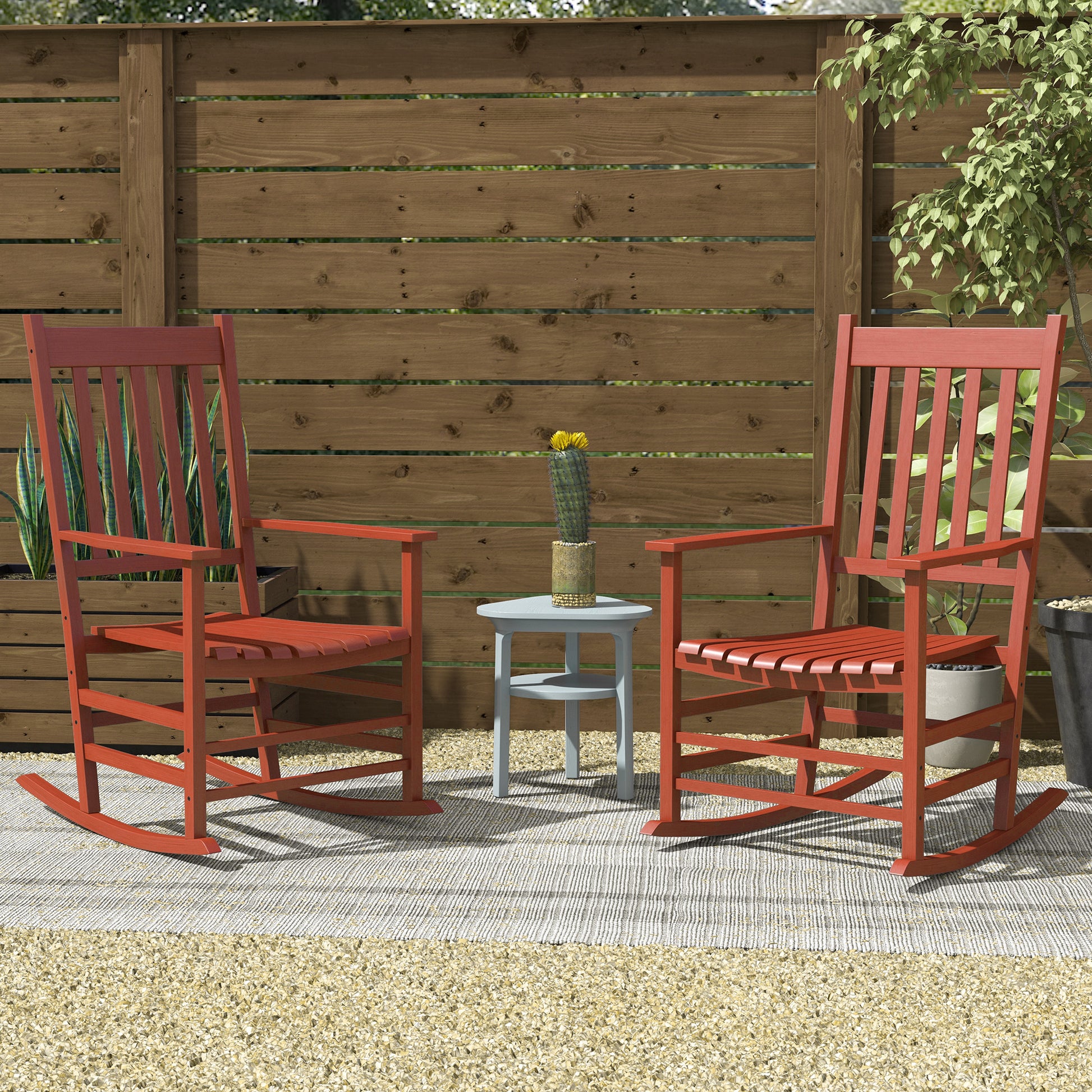 Two red wooden rocking chairs on a patio rug perfect for outdoor relaxation