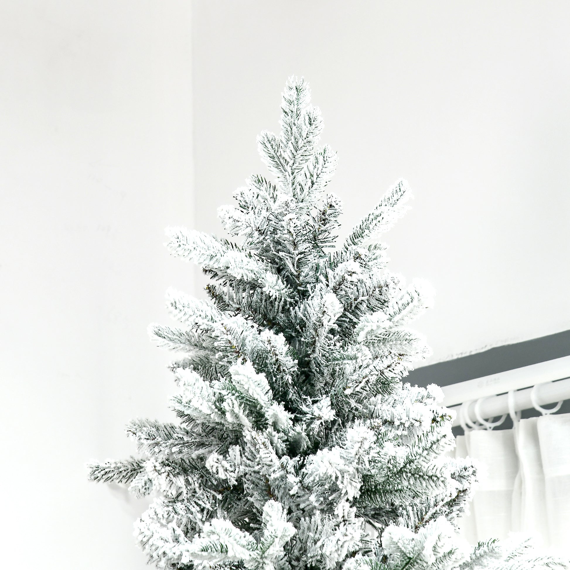 Flocked artificial Christmas tree with dense branches creating a winter wonderland aesthetic