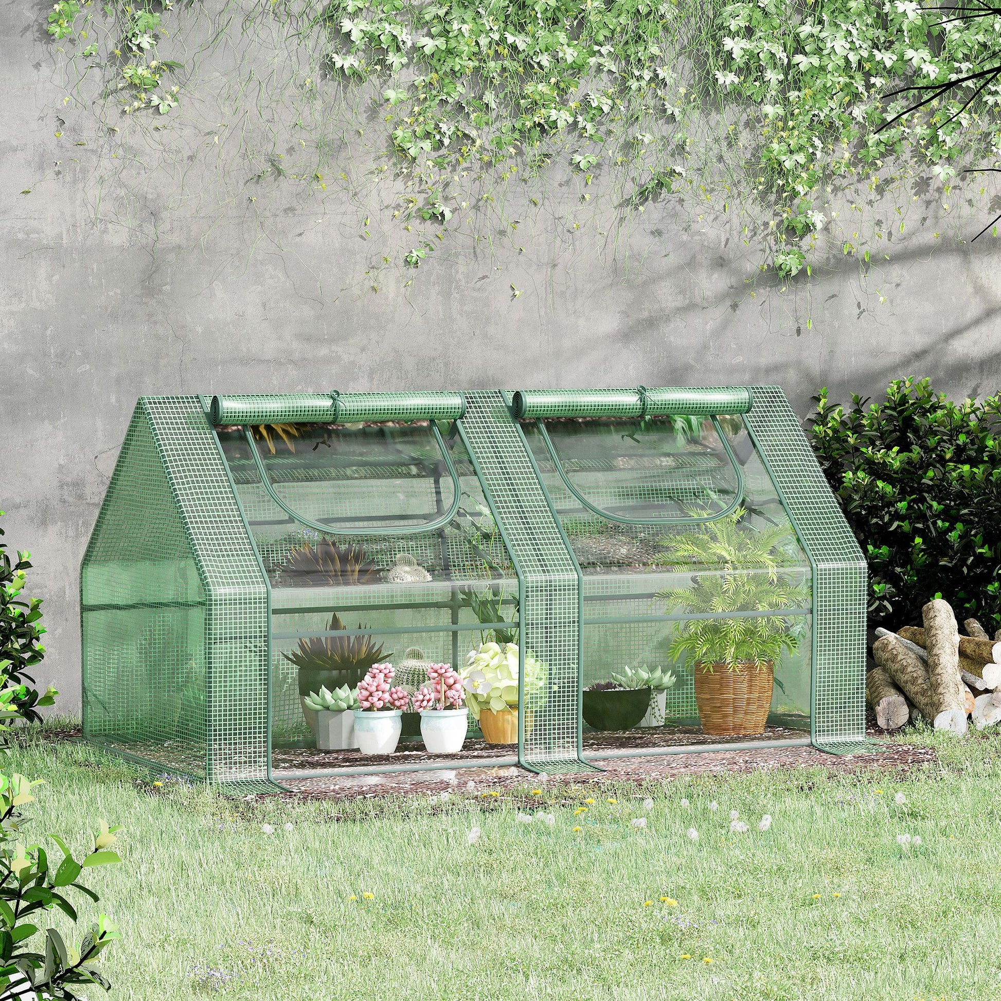 Green mesh mini greenhouse with tiered shelves displaying various potted plants