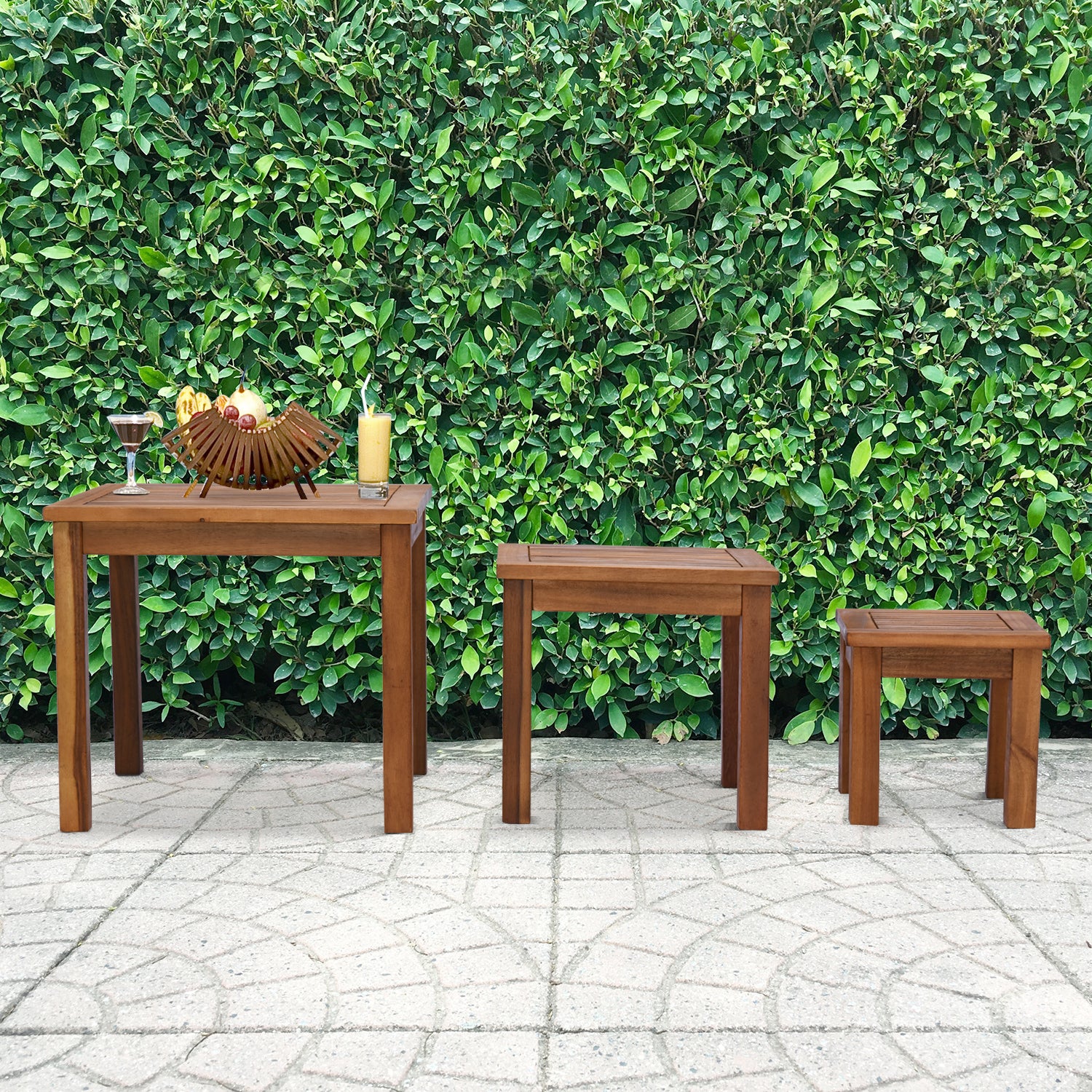 Three wooden outdoor tables of varying heights arranged on a patio
