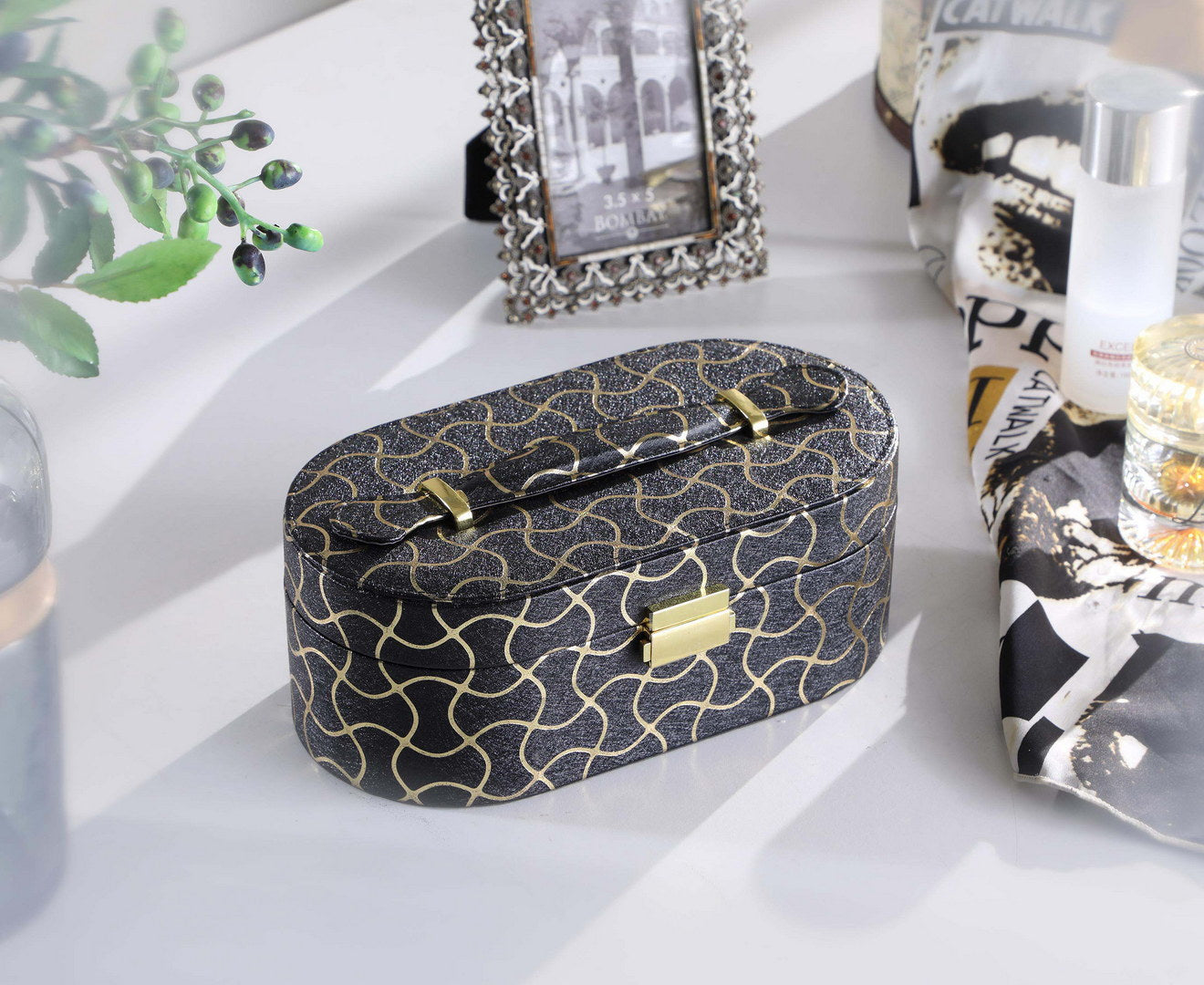 Oval black jewelry box with gold geometric pattern