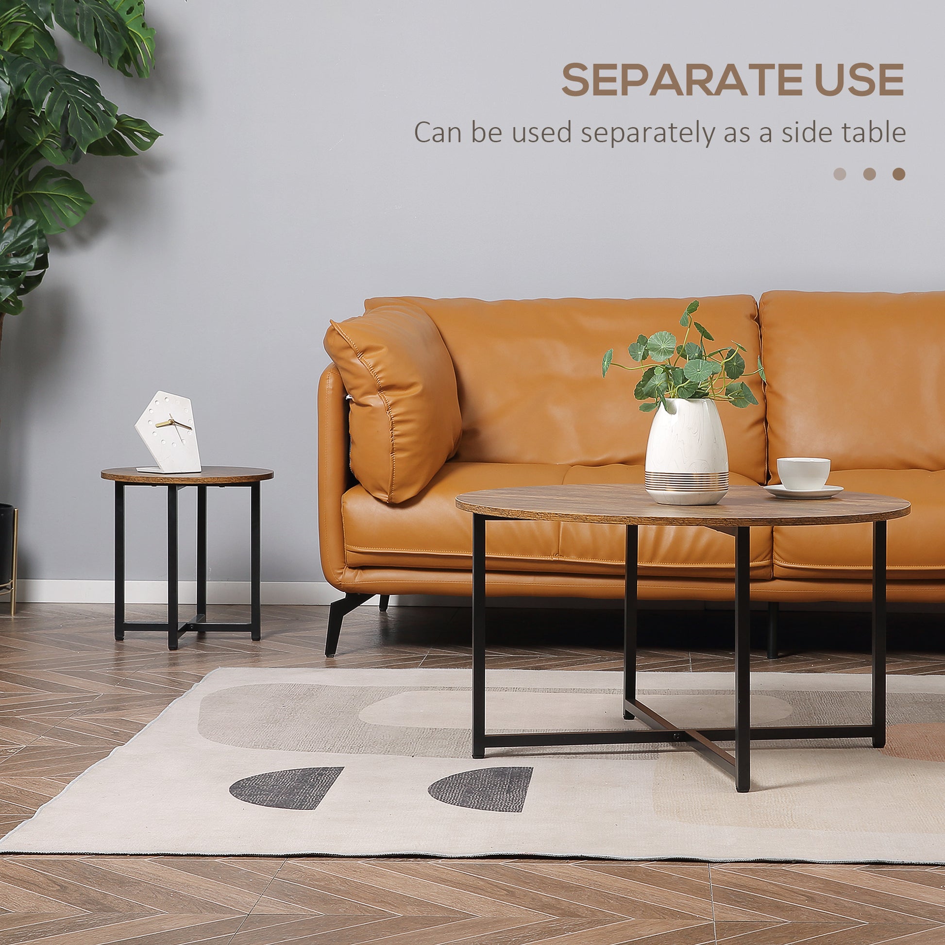 Round wooden coffee table with black metal legs beside a tan leather couch