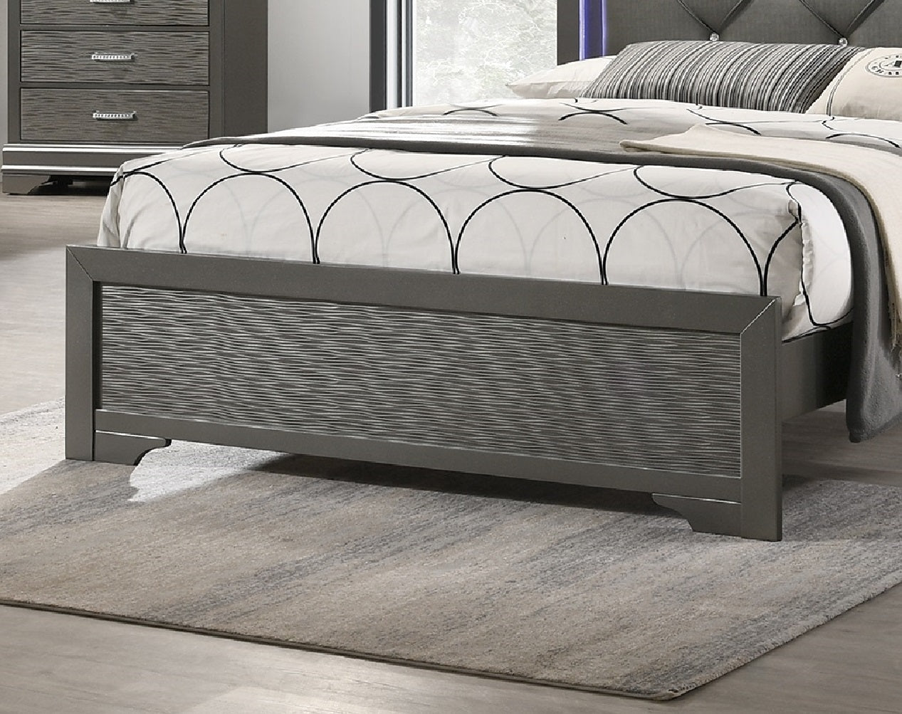 Gray upholstered platform bed with textured headboard and wavepatterned footboard