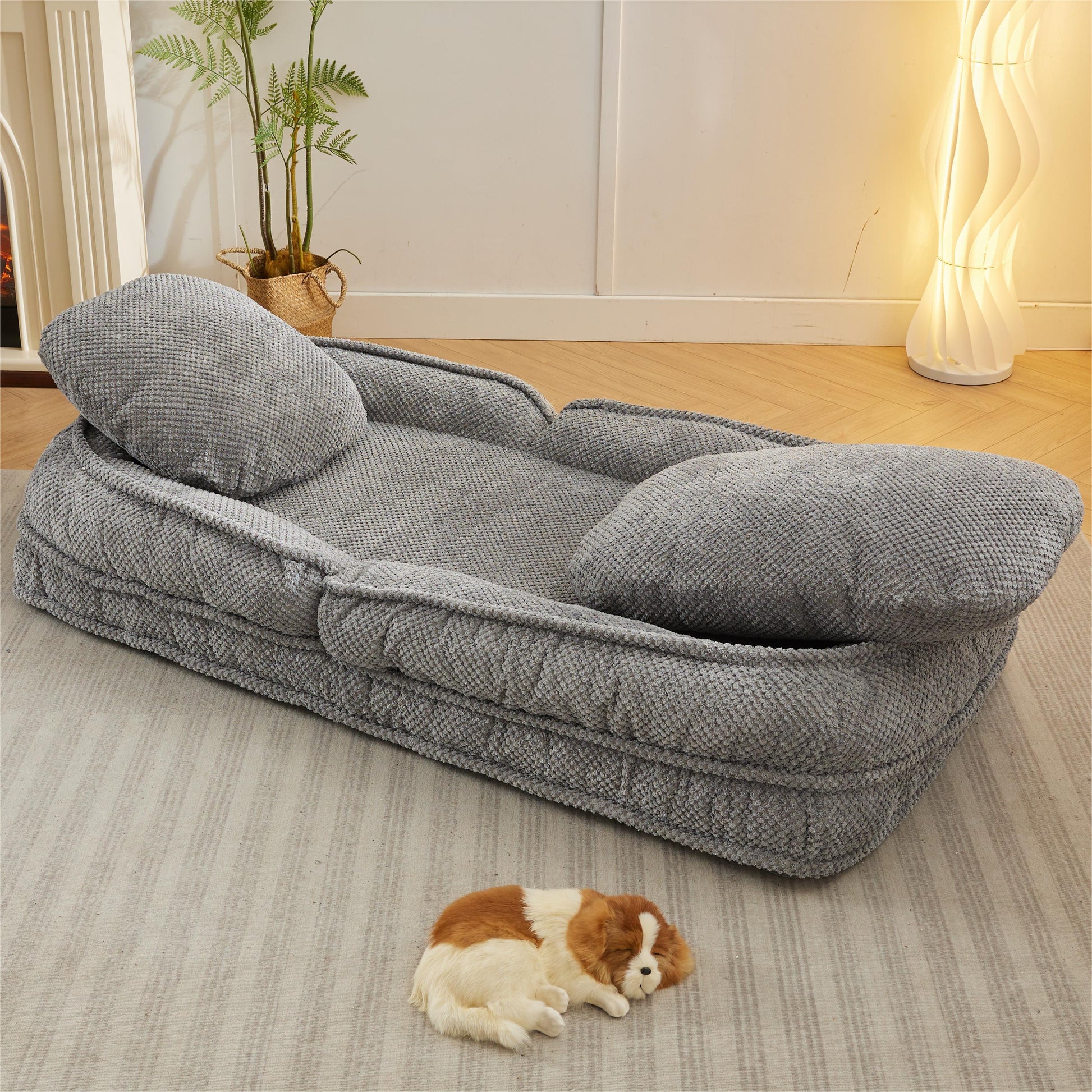 Plush gray dog bed with bolsters and two attached pillows for ultimate comfort