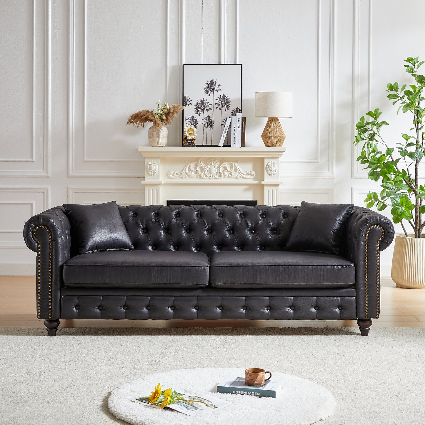 Dark charcoal tufted leather chesterfield sofa with brass nailhead trim and plush cushions