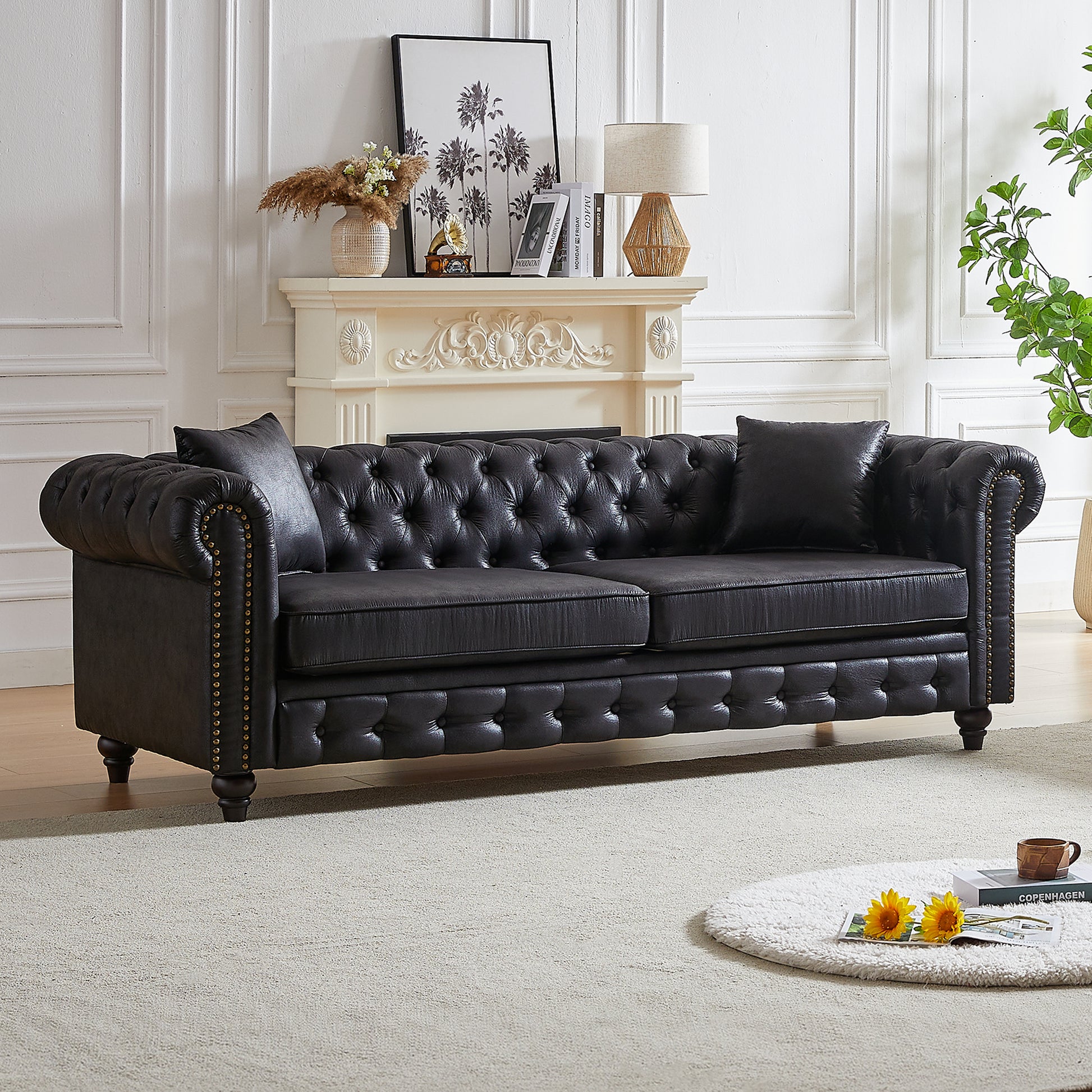 Black leather tufted chesterfield sofa with brass nailhead trim  characters