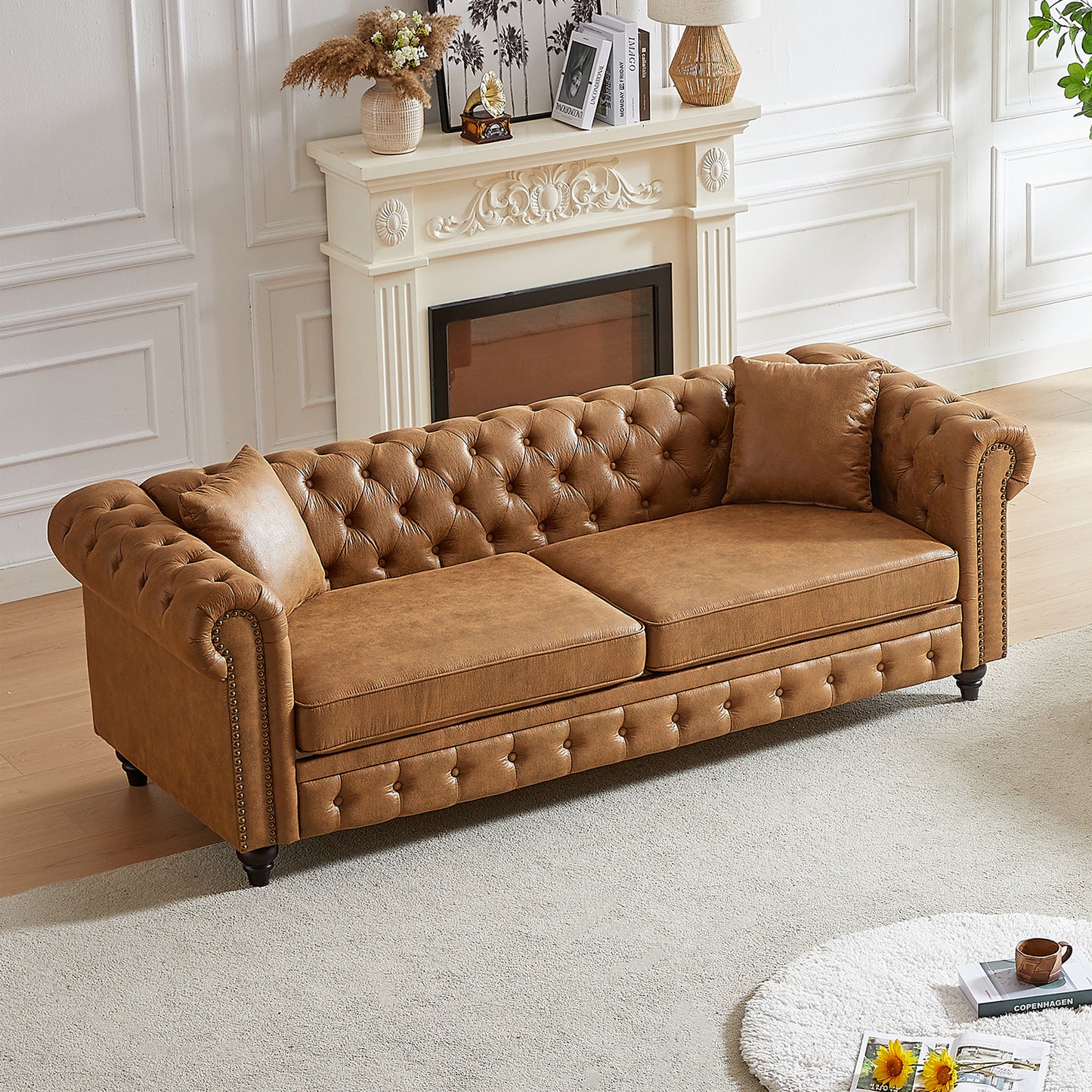 Brown faux leather chesterfield sofa with tufted cushions and ornate nailhead trim
