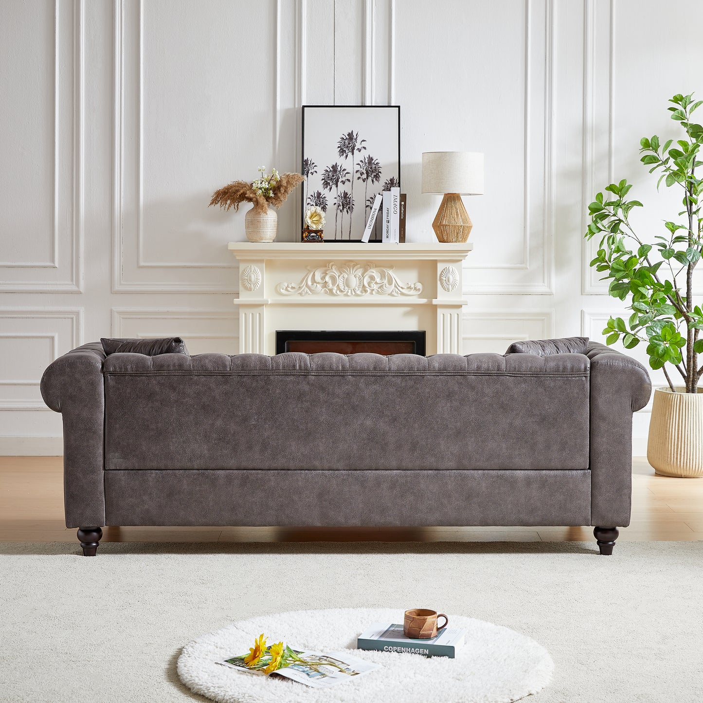 Dark grey tufted chesterfield sofa with rolled arms and dark wooden legs