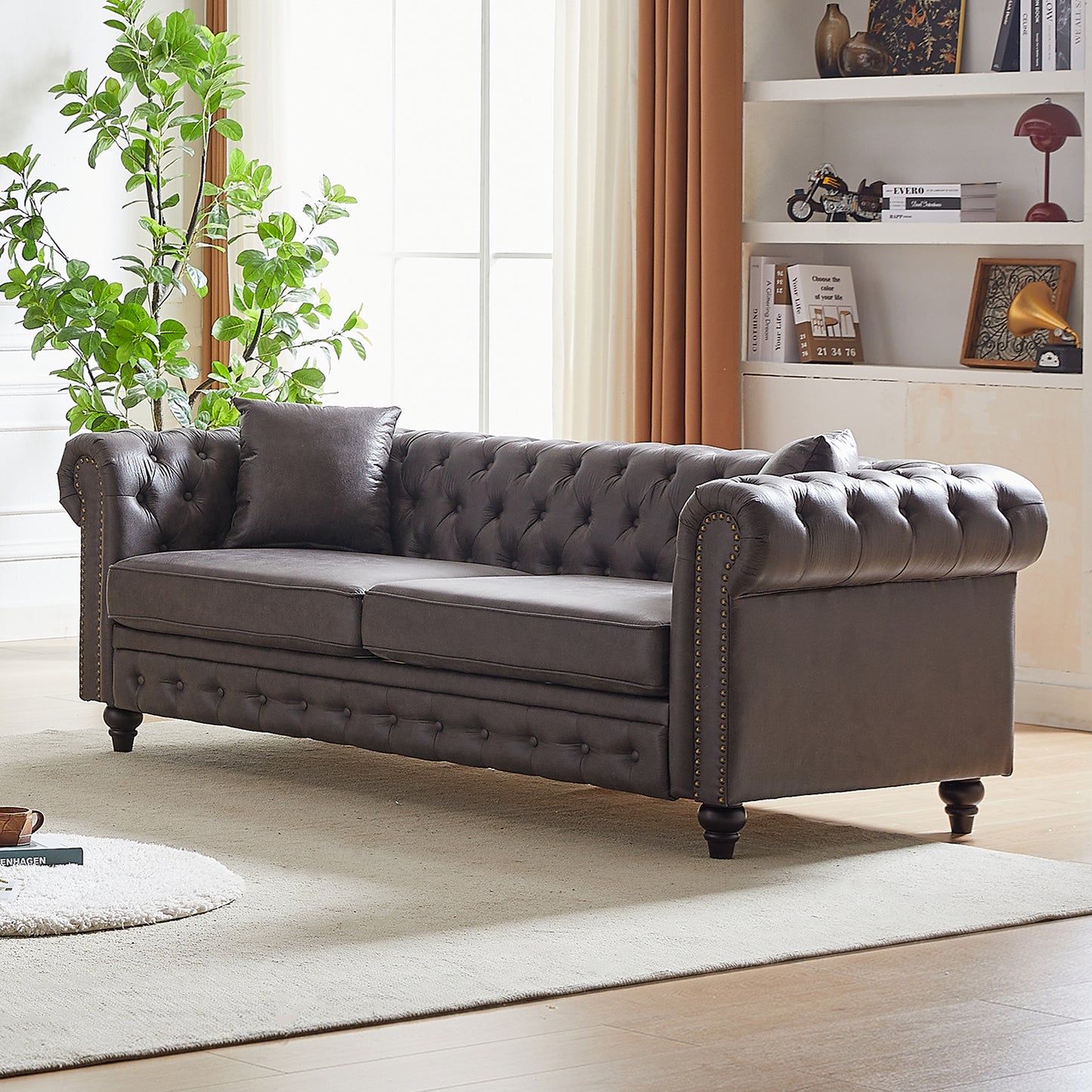 Dark grey tufted Chesterfield sofa with nailhead trim and plush cushions