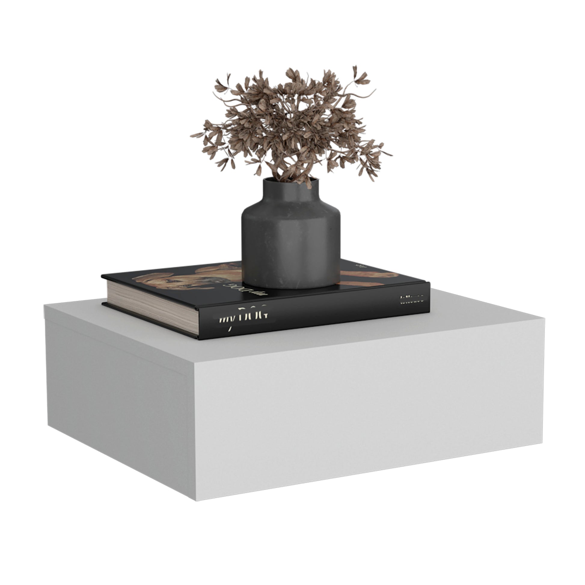 Minimalist grey vase with dried branches on a black art book atop a white floating shelf