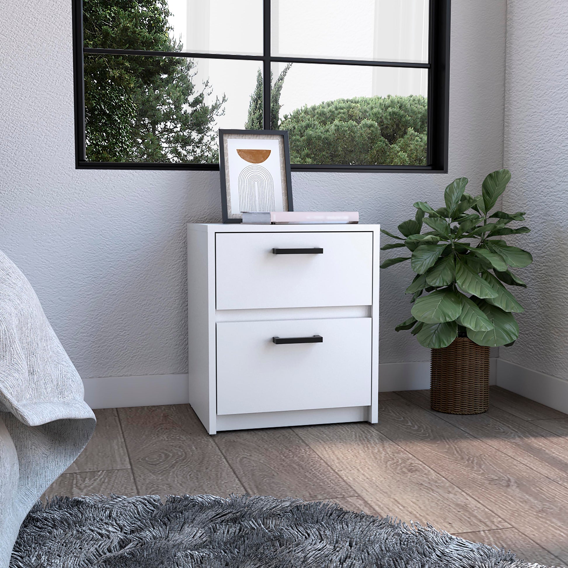 White twodrawer nightstand with black handles featuring art and books on top