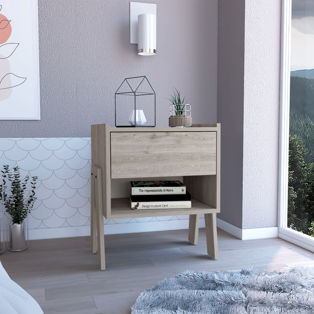 Light oak bedside table with drawer and open shelf displaying books and decor