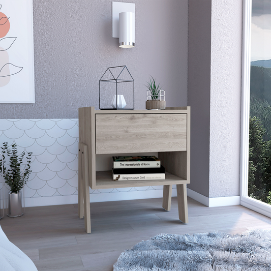 Light oak bedside table with drawer and open shelf displaying books and decor