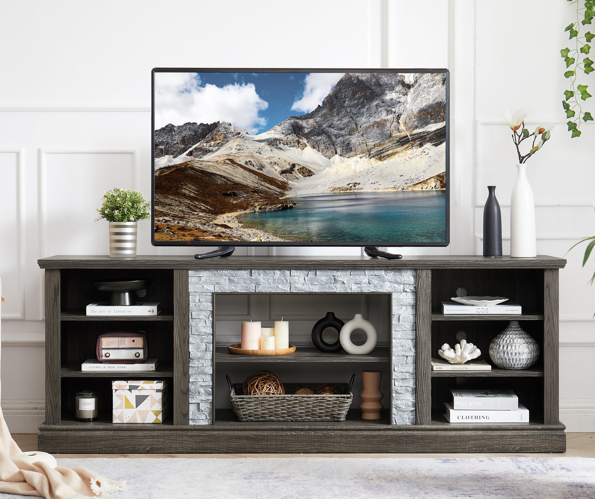 Dark gray wood TV stand with stone fireplace accent and open shelving for media consoles