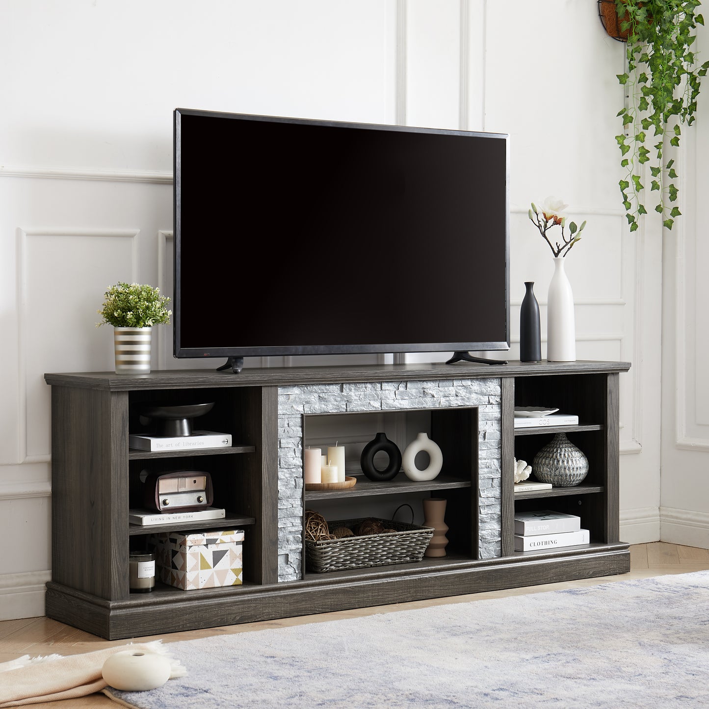 Dark gray wood TV stand with stone accents and multiple shelves for media storage and decor