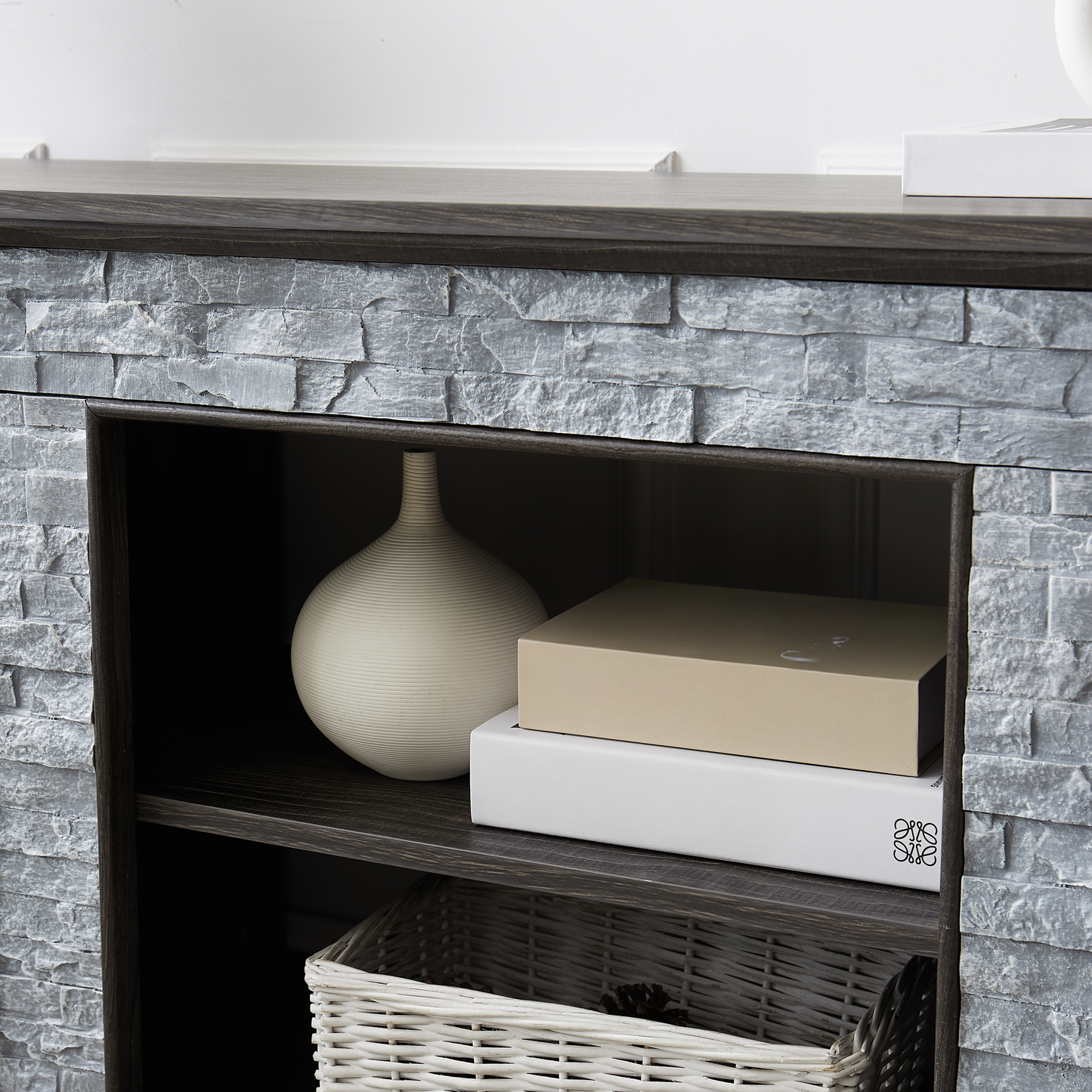 Grey stoneeffect fireplace with a beige decorative vase on shelf