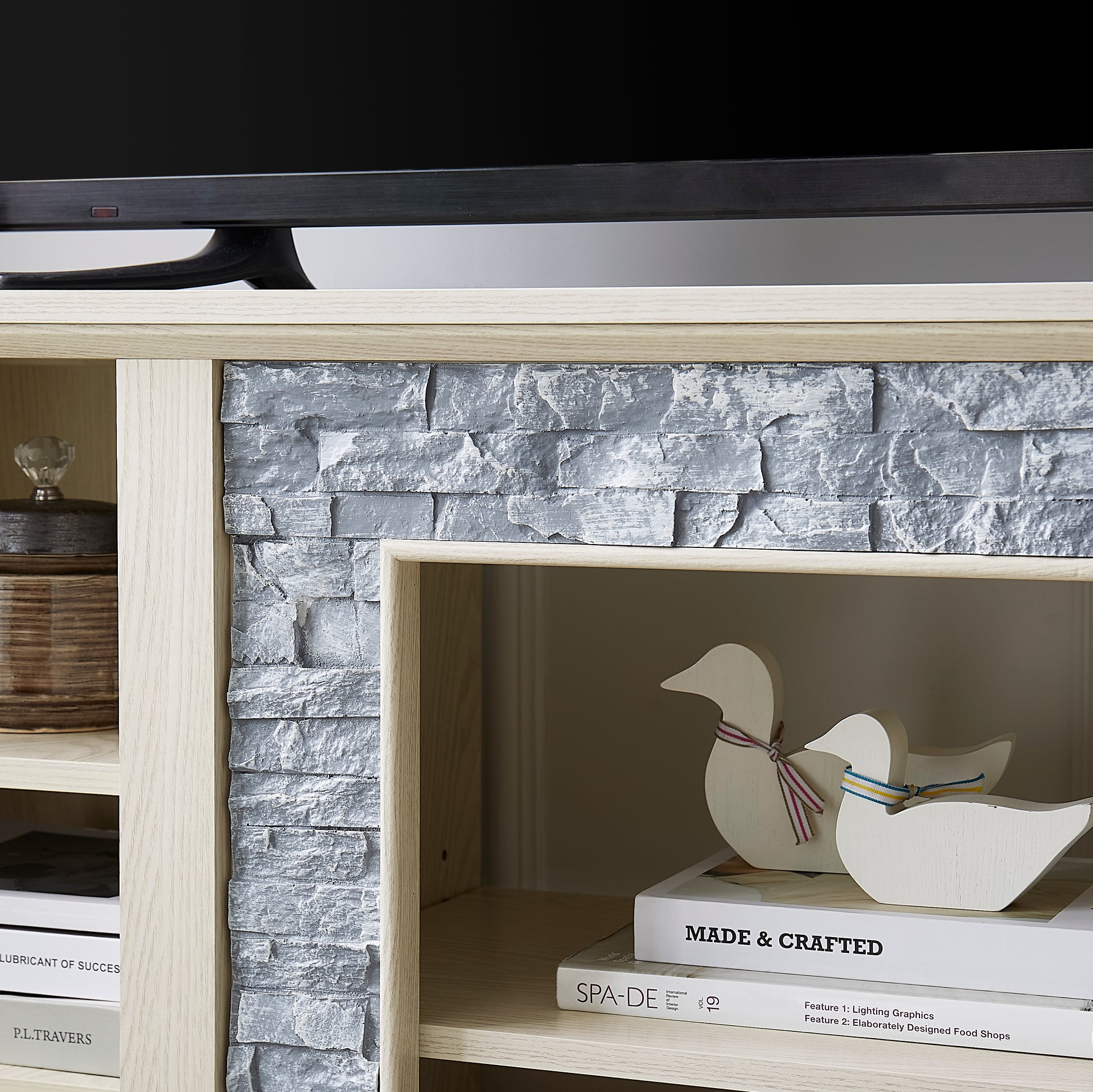 Light wood TV stand with grey stacked stone accent featuring two decorative wooden ducks