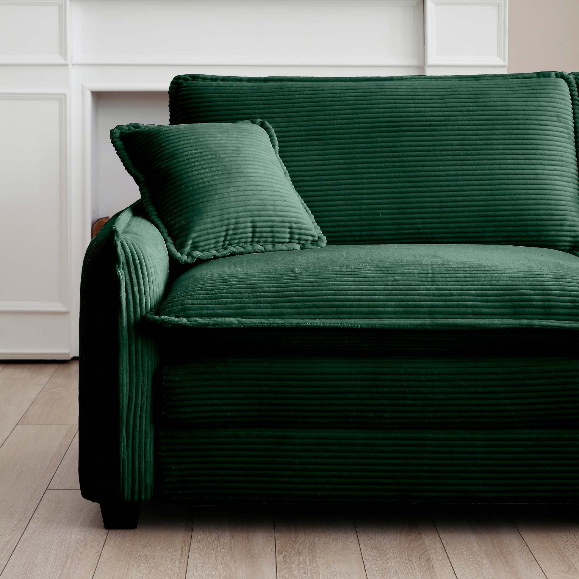 Deep green corduroy sofa with plush cushions adding texture to any living room